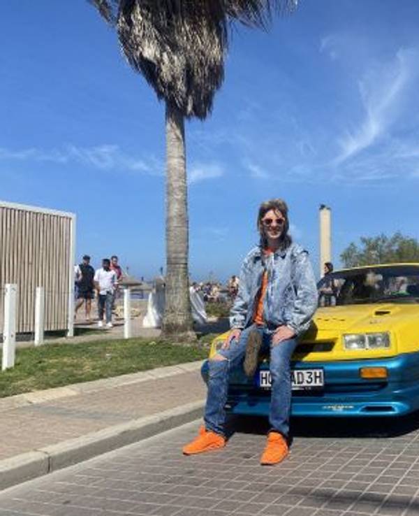 Manni Manta sitzt auf dem Opel Manta am Ballermann auf Mallorca.