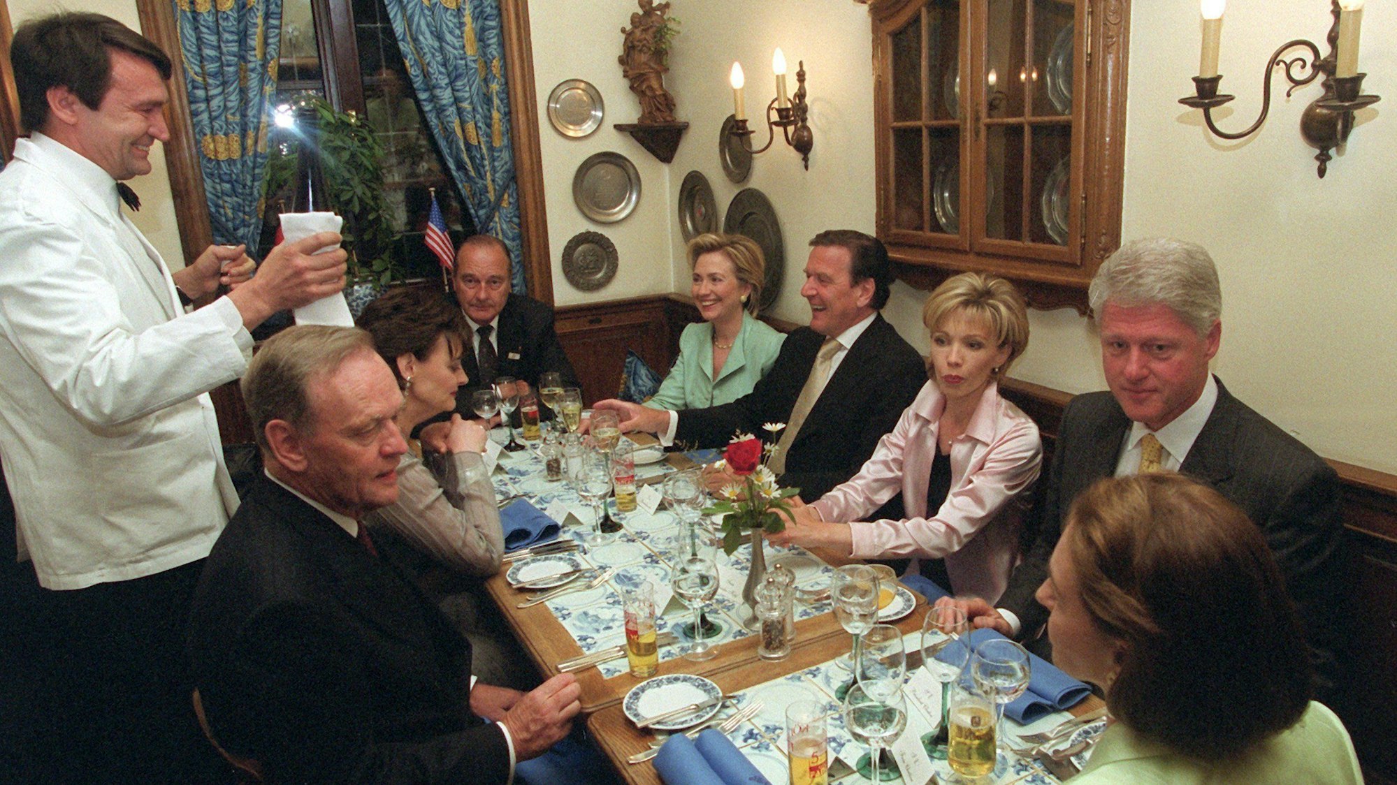 Während ein Kellner Wein ausschenkt, unterhalten sich (von links im Uhrzeigersinn) Jean Chretien, Cherie Blair, Jacques Chirac, Hillary Clinton, Gerhard Schröder, Doris Schröder-Köpf, Bill Clinton und Aline Chretien in Köln