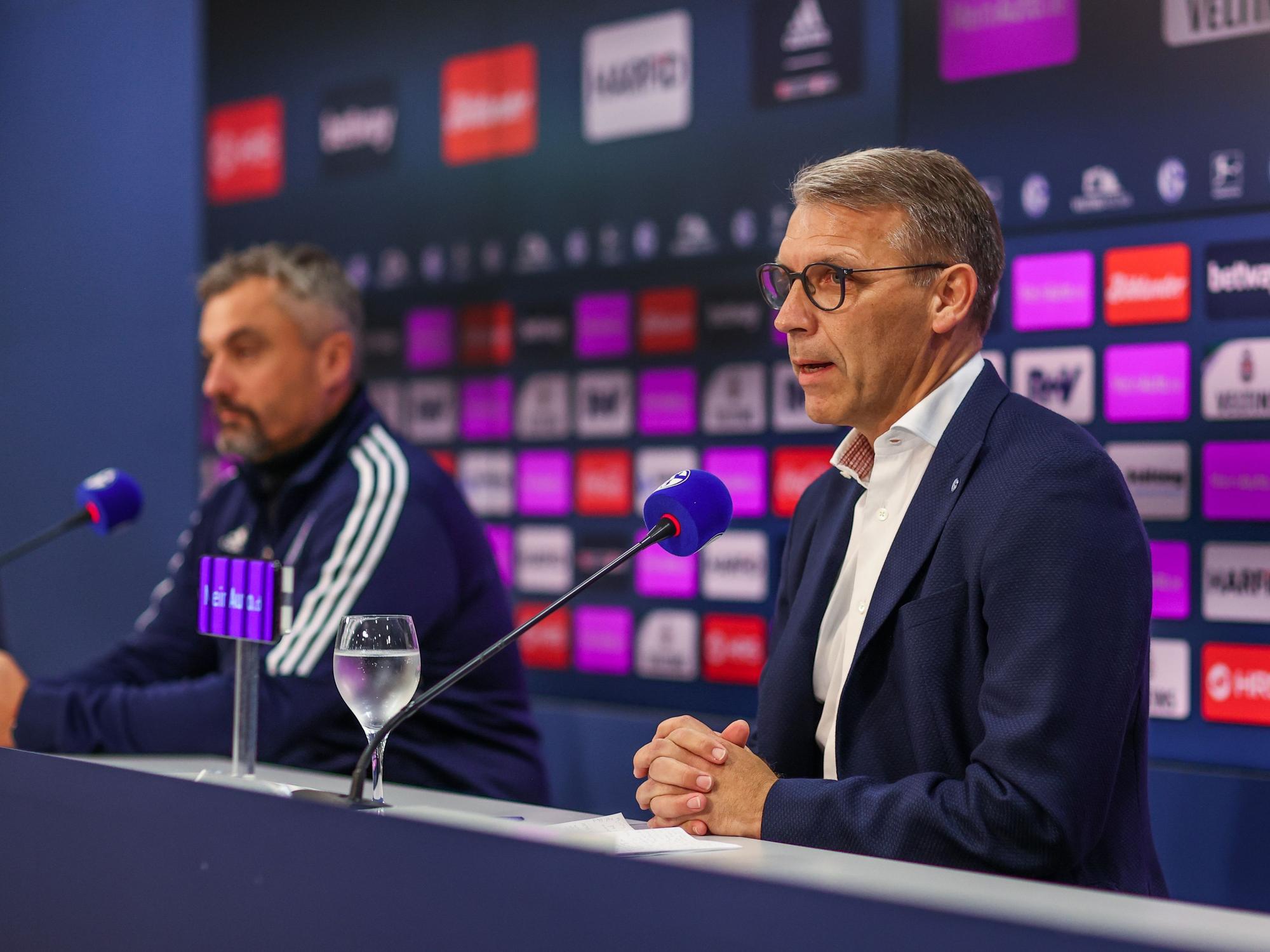 Schalkes Cheftrainer Thomas Reis gemeinsam mit Sportvorstand Peter Knäbel auf einer Pressekonferenz.