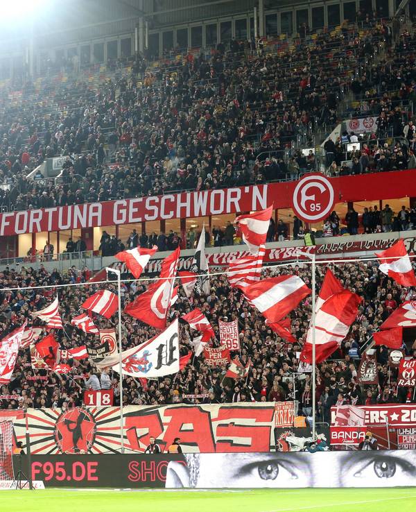 Fans von Fortuna Düsseldorf schwenken ihre Fahnen vor Spielbeginn.
