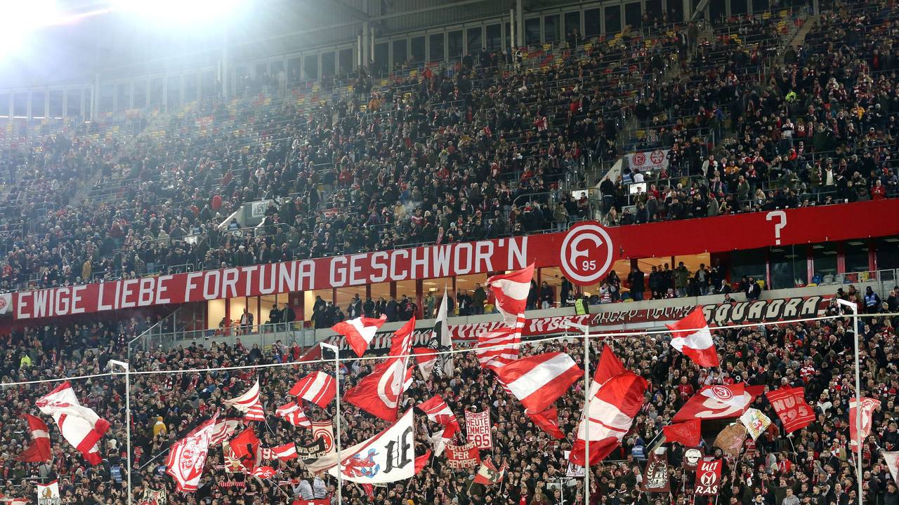 Fans von Fortuna Düsseldorf schwenken ihre Fahnen vor Spielbeginn.