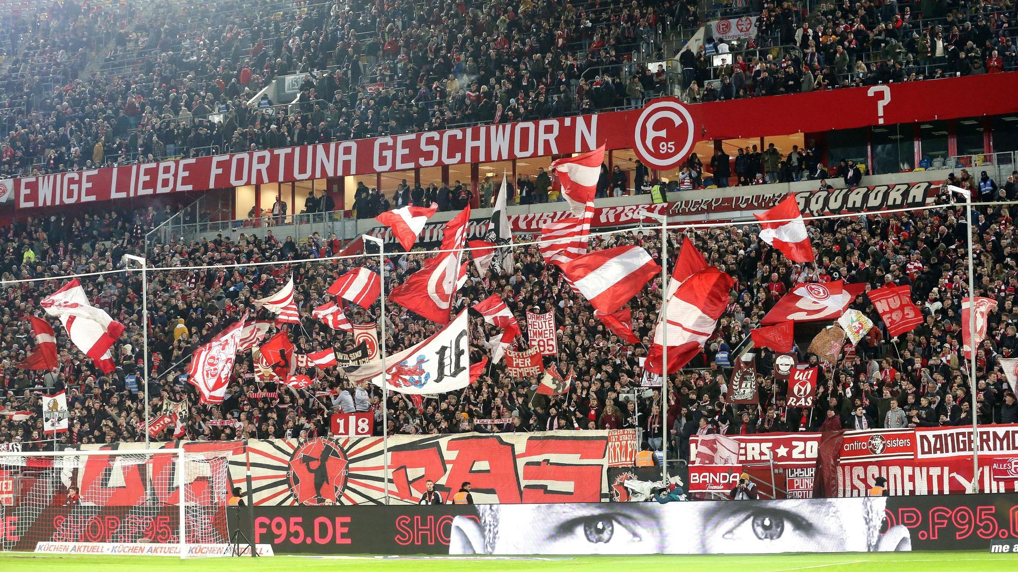 Fans von Fortuna Düsseldorf schwenken ihre Fahnen vor Spielbeginn.