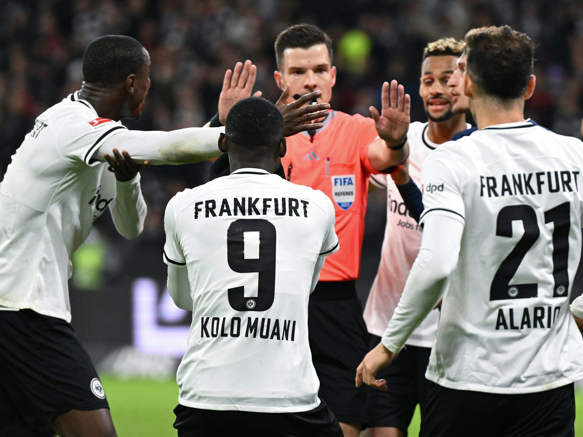 Die Frankfurter Spieler Evan Ndicka, Randal Kolo Muani, Djibril Sow und Lucas Alariof reklamieren Handspiel bei Schiedsrichter Harm Osmers.
