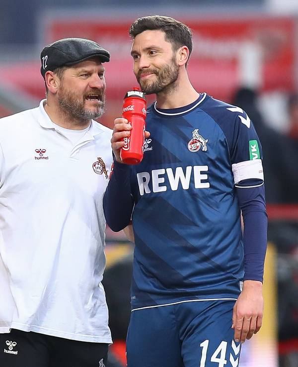 Steffen Baumgart spricht grinsend mit Jonas Hector.