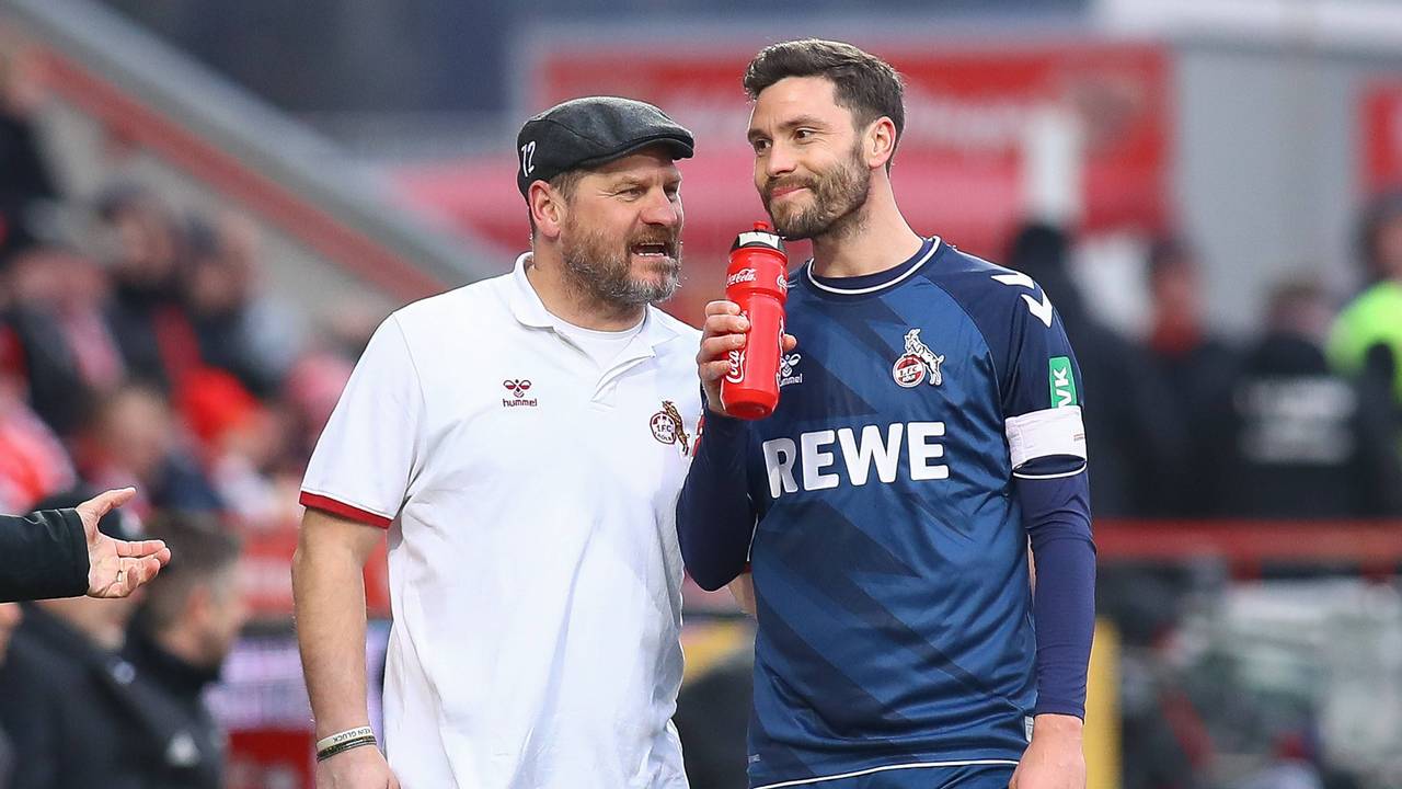 Steffen Baumgart spricht grinsend mit Jonas Hector.
