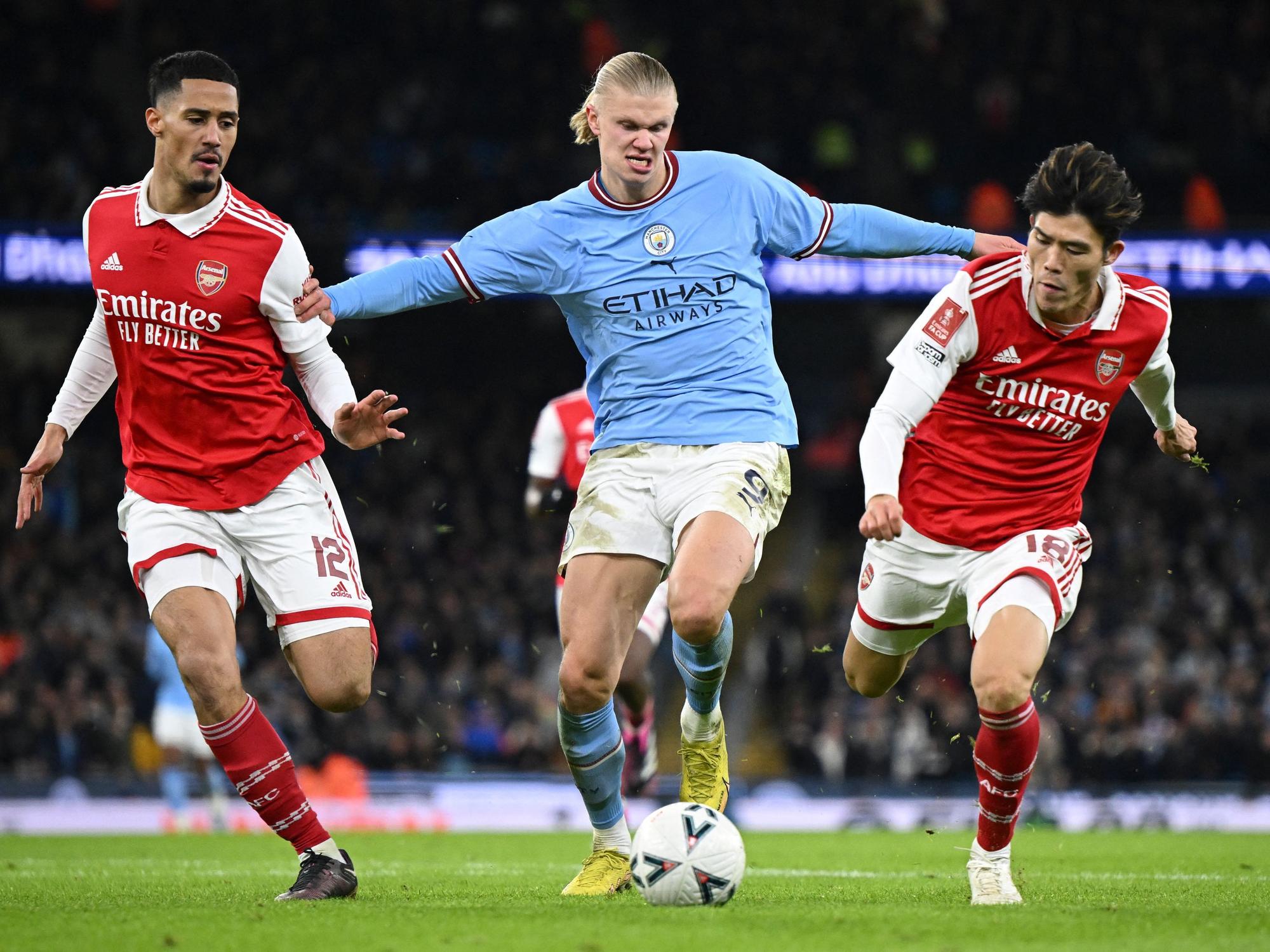 Manchester City Stürmer Erling Haaland (m.) im Zweikampf mit Takehiro Tomiyasu (r.) und William Saliba (l.) beim letzten Aufeinadertreffen beider Teams am 27. Januar 2023