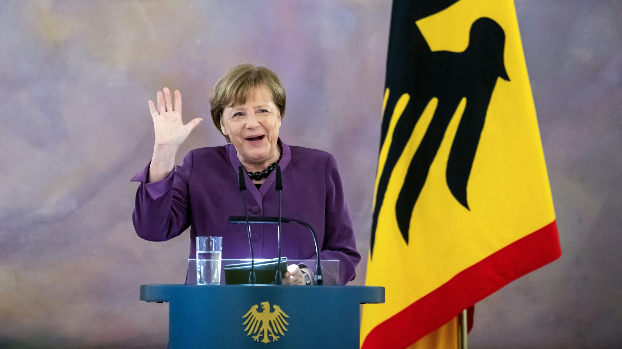 Altkanzlerin Angela Merkel steht an einem Rednerpult und gestikuliert während einer Rede.