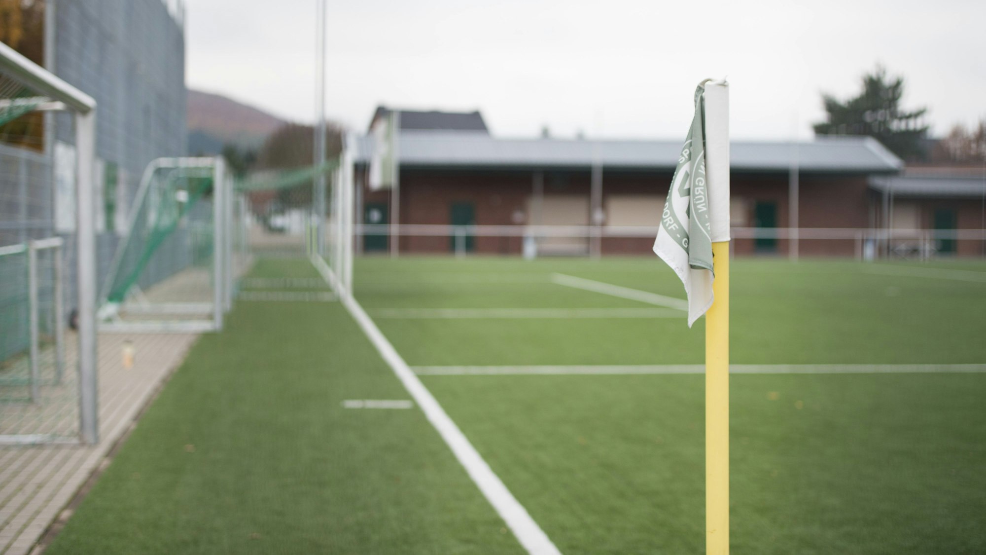 Blick auf einen Fußballplatz mit der Eckfahne im Vordergrund.