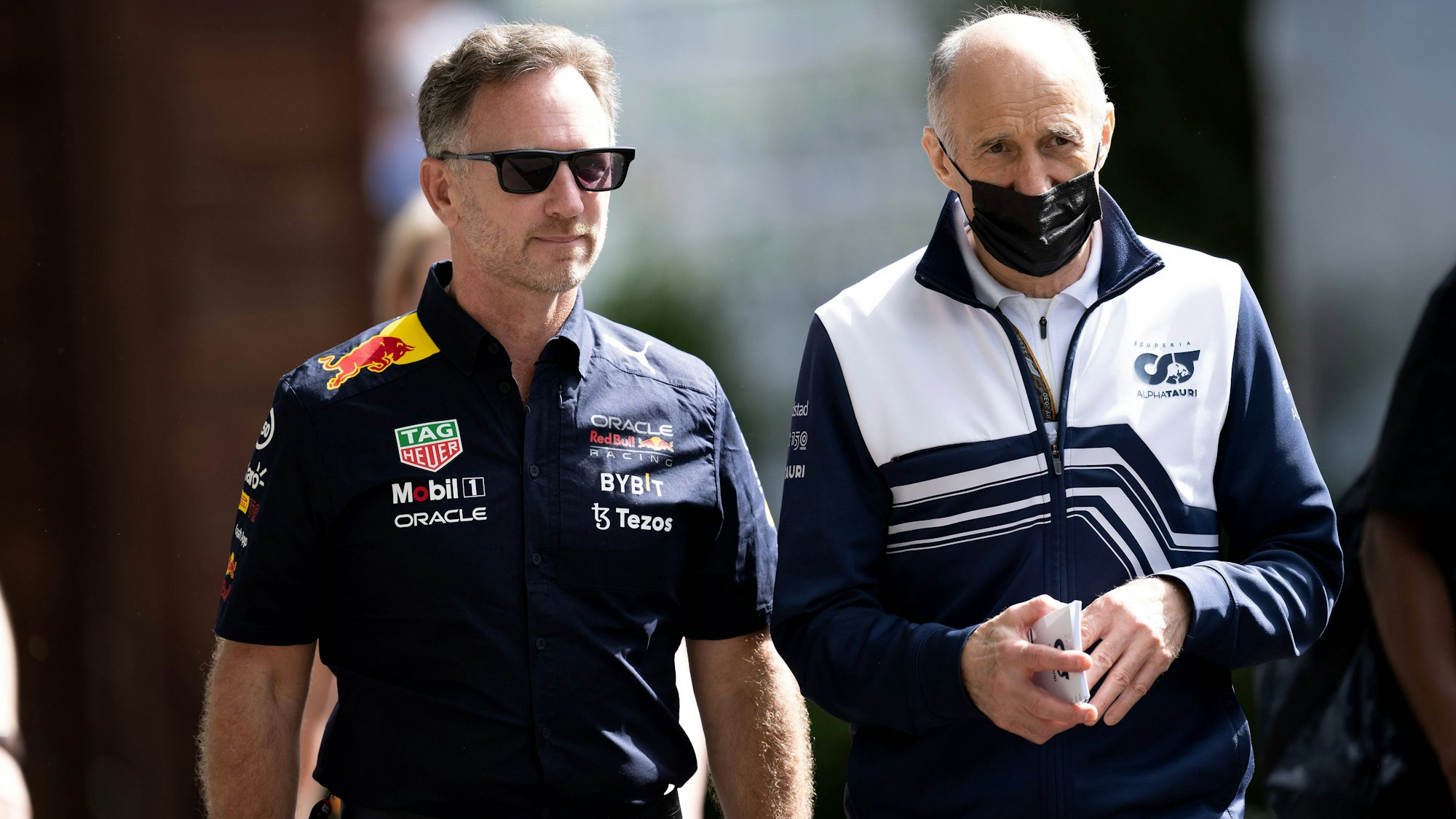Red-Bull-Teamchef Christian Horner (l.) und Alpha-Tauri-Teamchef Franz Tost gehen in Richtung Fahrerlager.