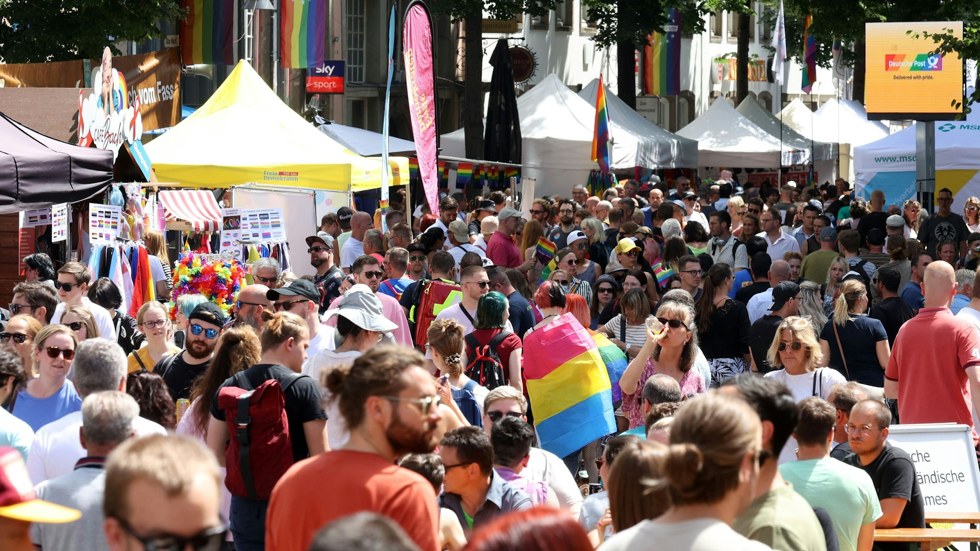 Menschen feiern beim CSD-Straßenfest in Köln in der Altstadt.