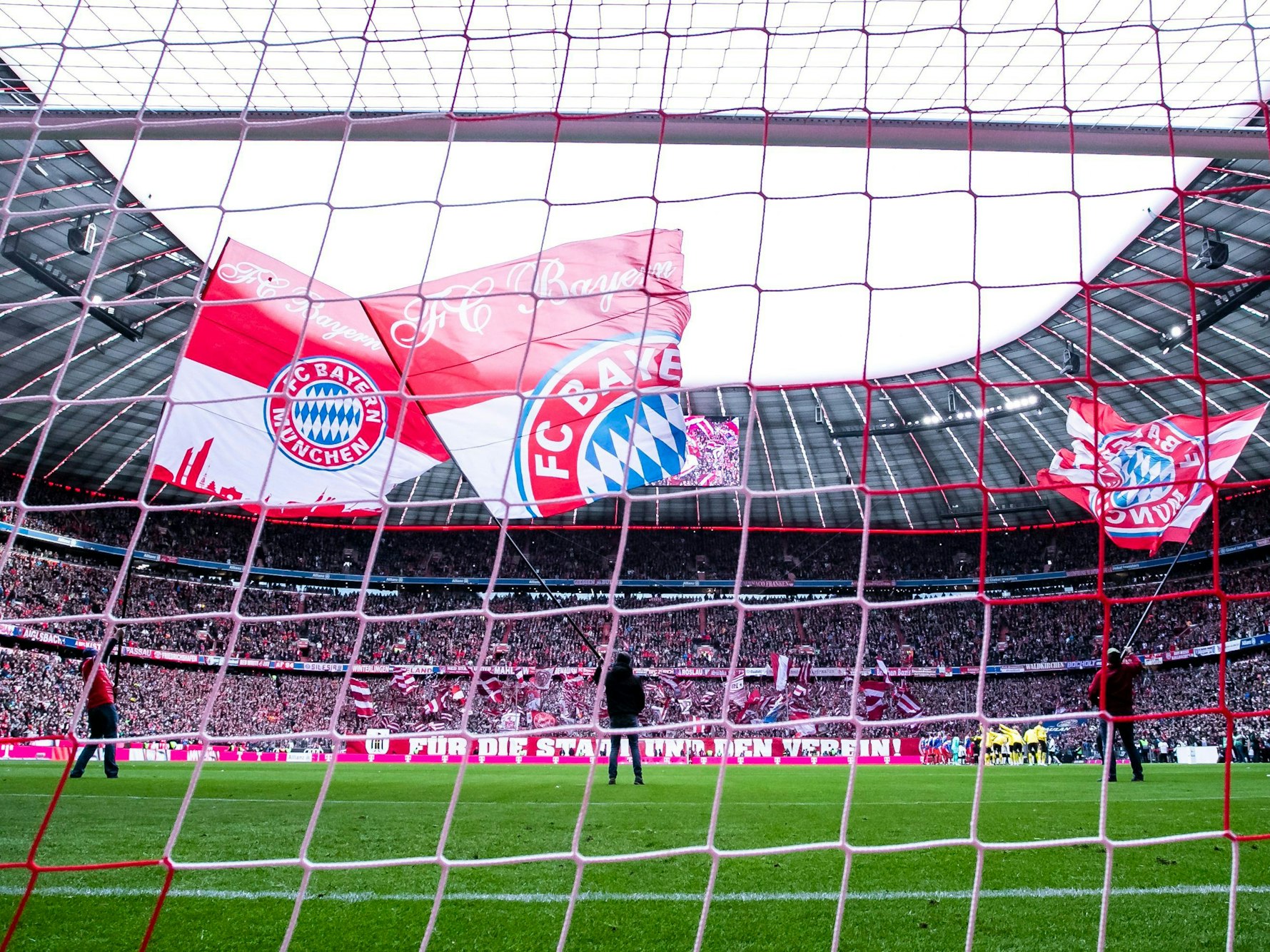 Fahnen des FC Bayern München werden vor dem Spiel in der Allianz-Arena geschwenkt.