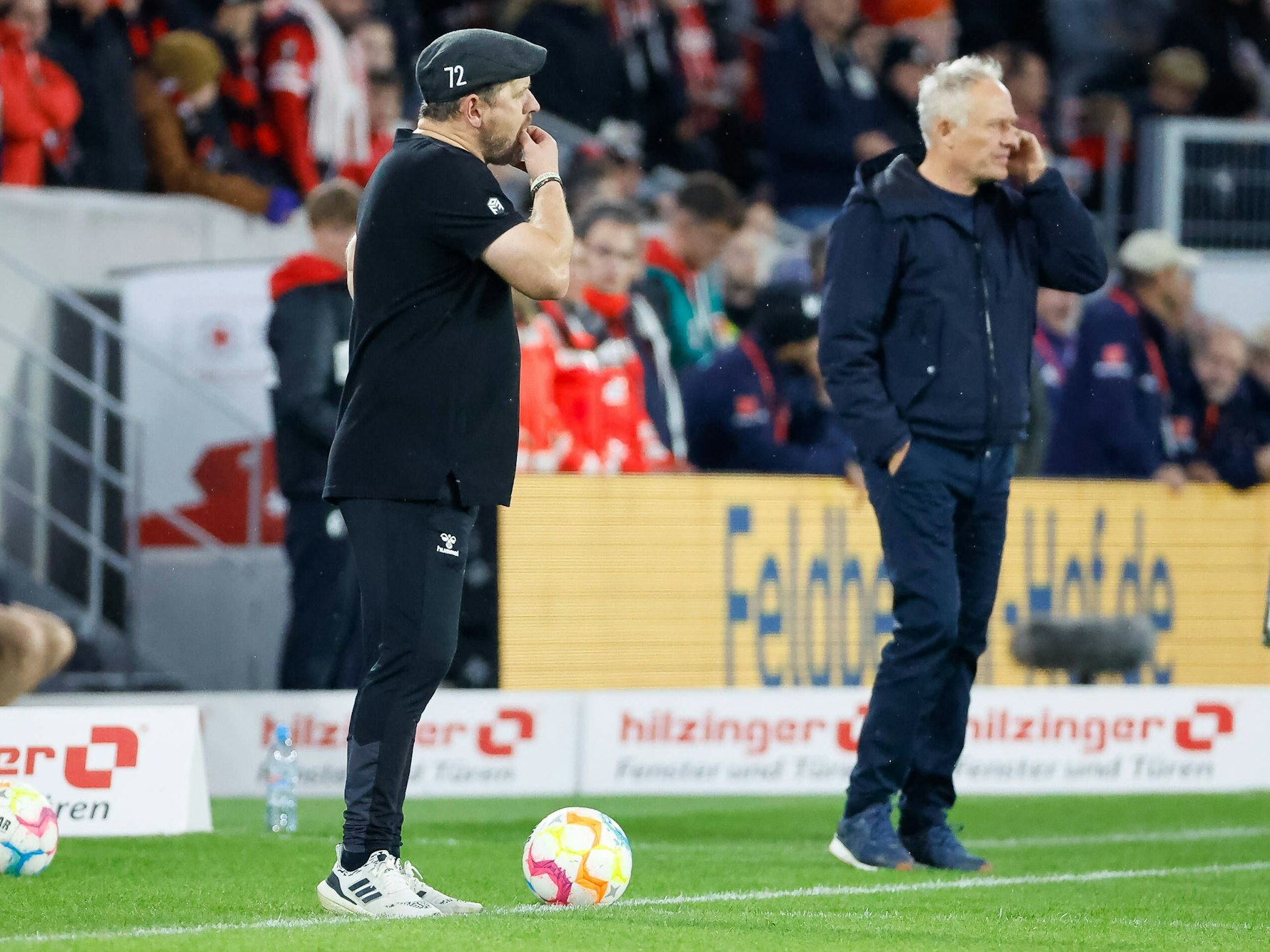 Steffen Baumgart und Christian Streich stehen beim Bundesliga-Spiel SC Freiburg gegen 1. FC Köln an der Seitenlinie.