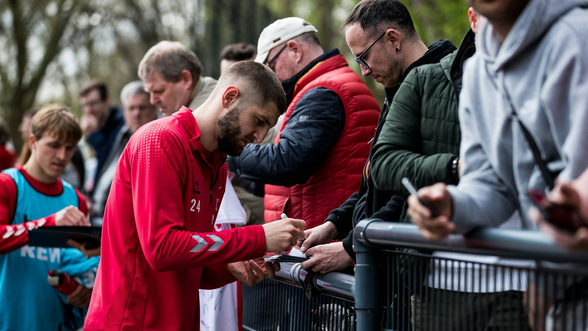 Jeff Chabot schreibt nach dem Training des 1. FC Köln Autogramme.