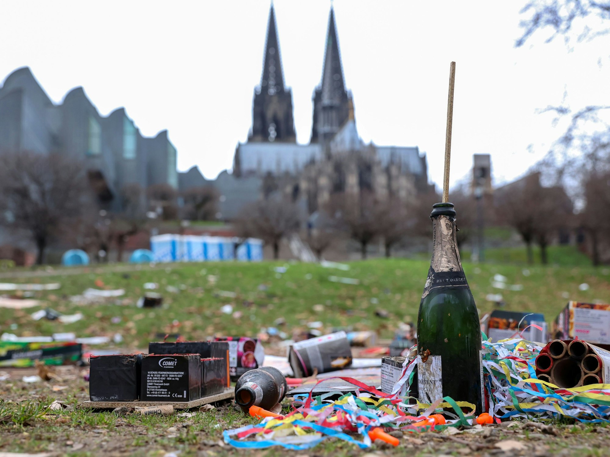 Müll in Köln auf einer Wiese vor dem Dom. Es sind Überreste von Silvester-Feierlichkeiten.