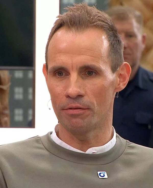 Sascha Stegemann sitzt als Gast beim Doppelpass. Im Hintergrund ist ein uniformierter Polizist zu sehen.
