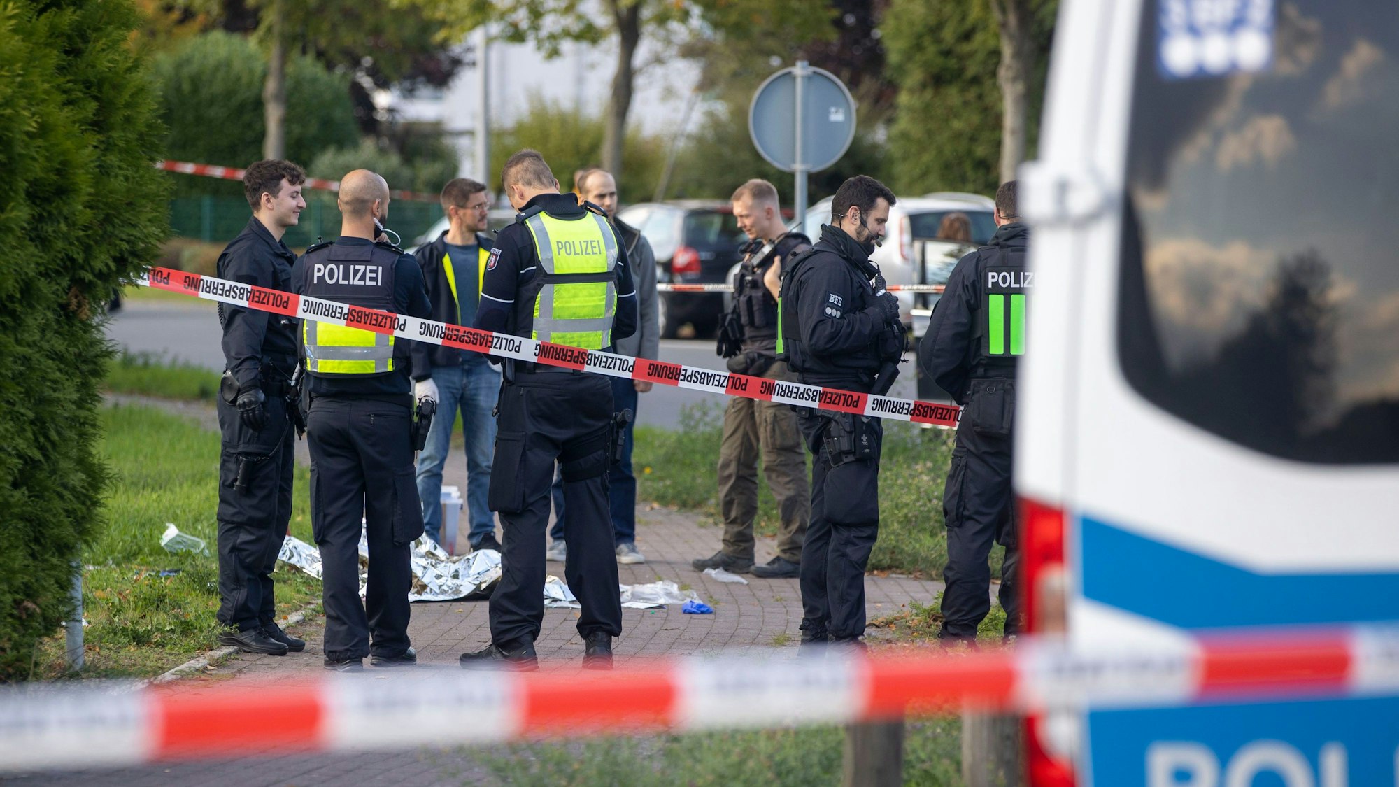 Diverse Polizisten stehen an einem Einsatzort in Dormagen, der Tatort ist urch Flatterband abgesperrt.