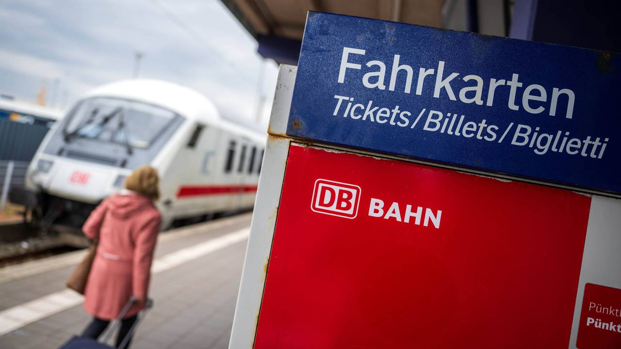 Touristen laufen mit Rollkoffern am Bahnhof Norddeich-Mole entlang.