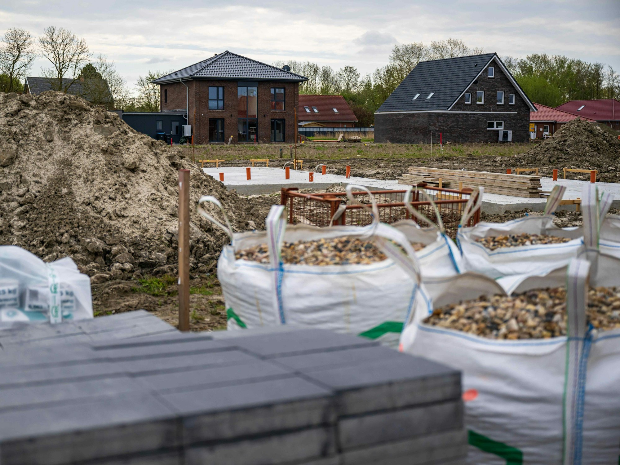 Das Symbolfoto vom 27. April 2023 zeigt mehrere Neubauten im Hintergrund und Baumaterialien im Vordergrund.