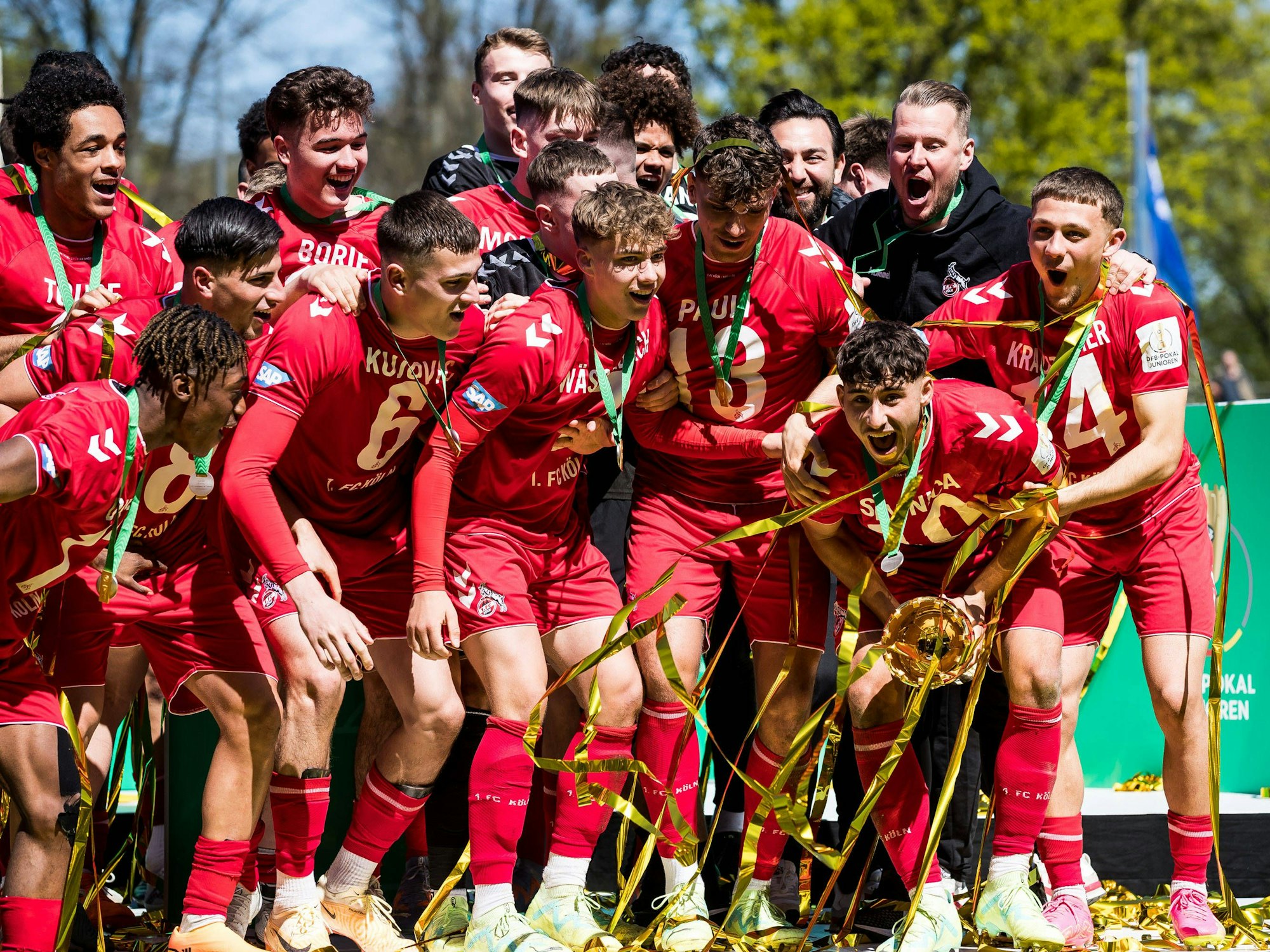 Luan Simnica hält nach dem Finalsieg gegen Schalke den Pokal in Händen. Seine Mitspieler jubeln mit ihm.