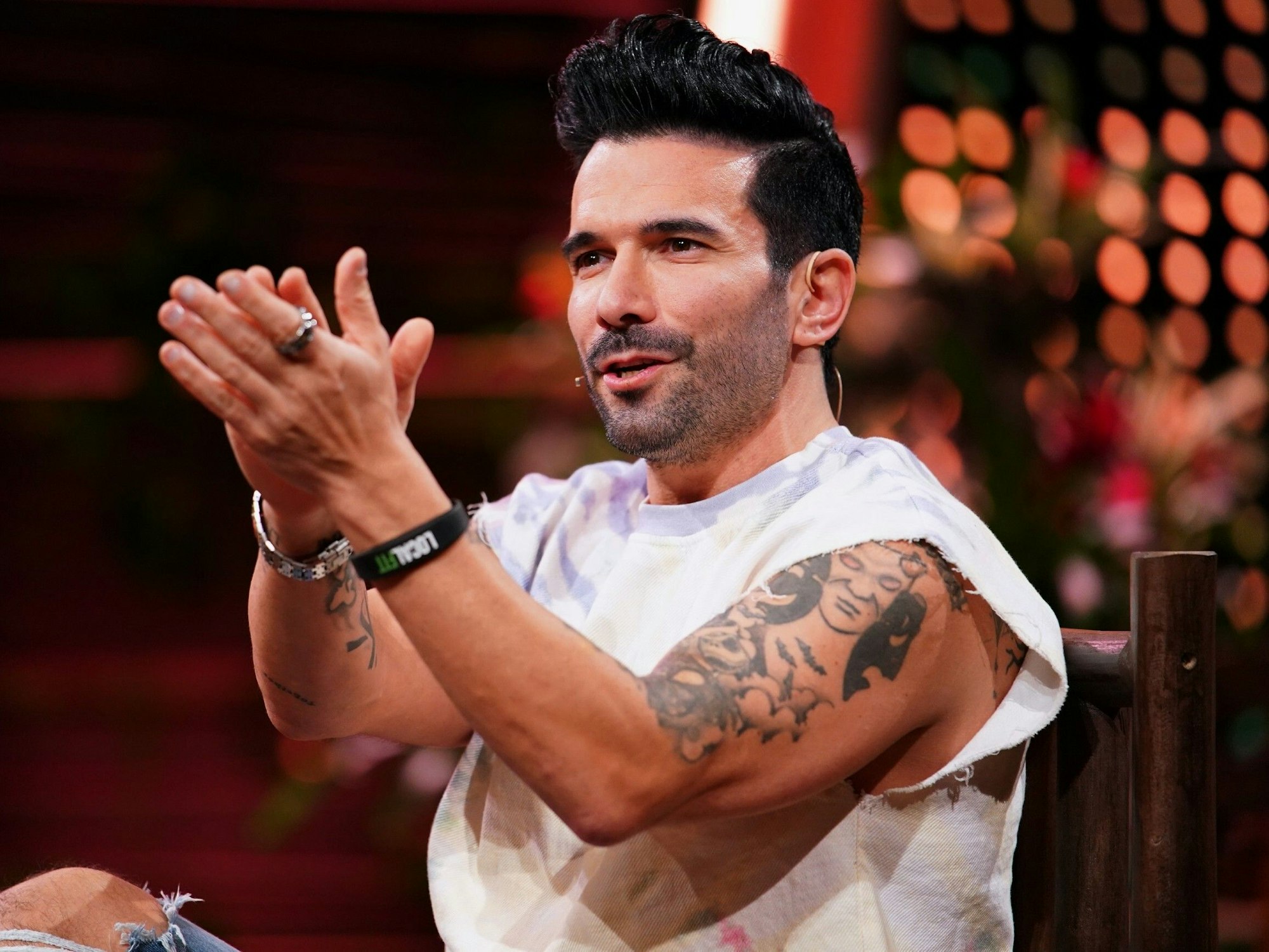 Marc Terenzi trägt ein weißes Shirt und klatscht in Richtung Kamera.