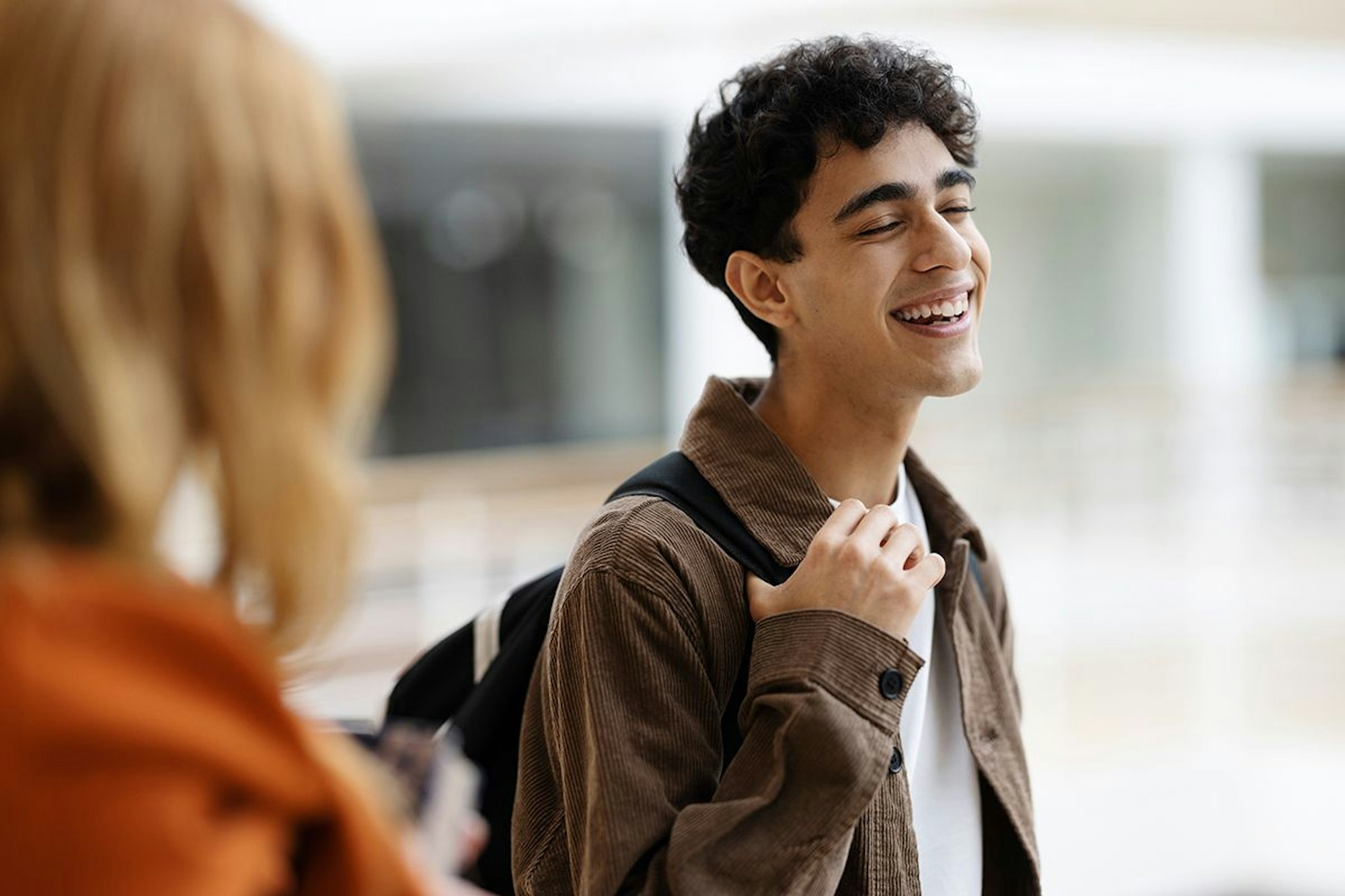 Lachender Schüler mit Rucksack