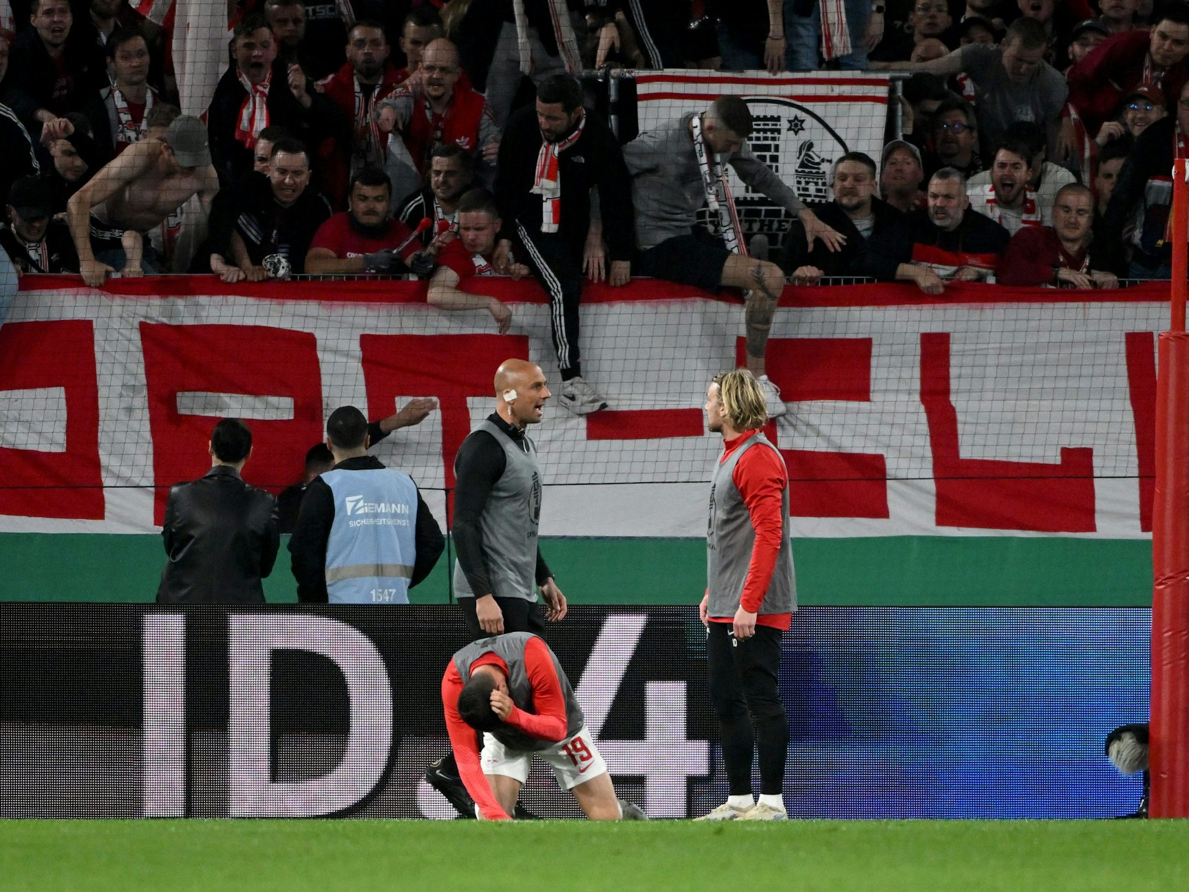 Leipzigs Andre Silva geht vor dem Freiburger Fanblock zu Boden.