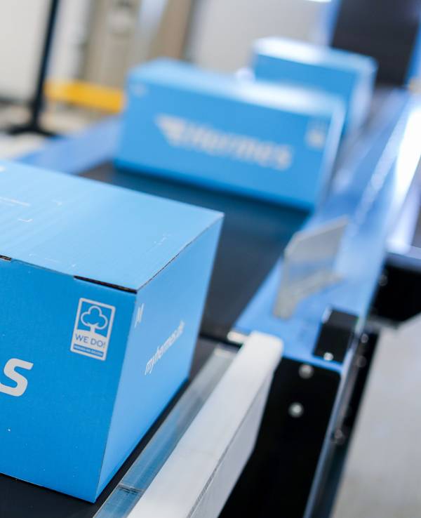 Pakete liegen auf einem Förderband im neuen Hermes Logistik-Center.
