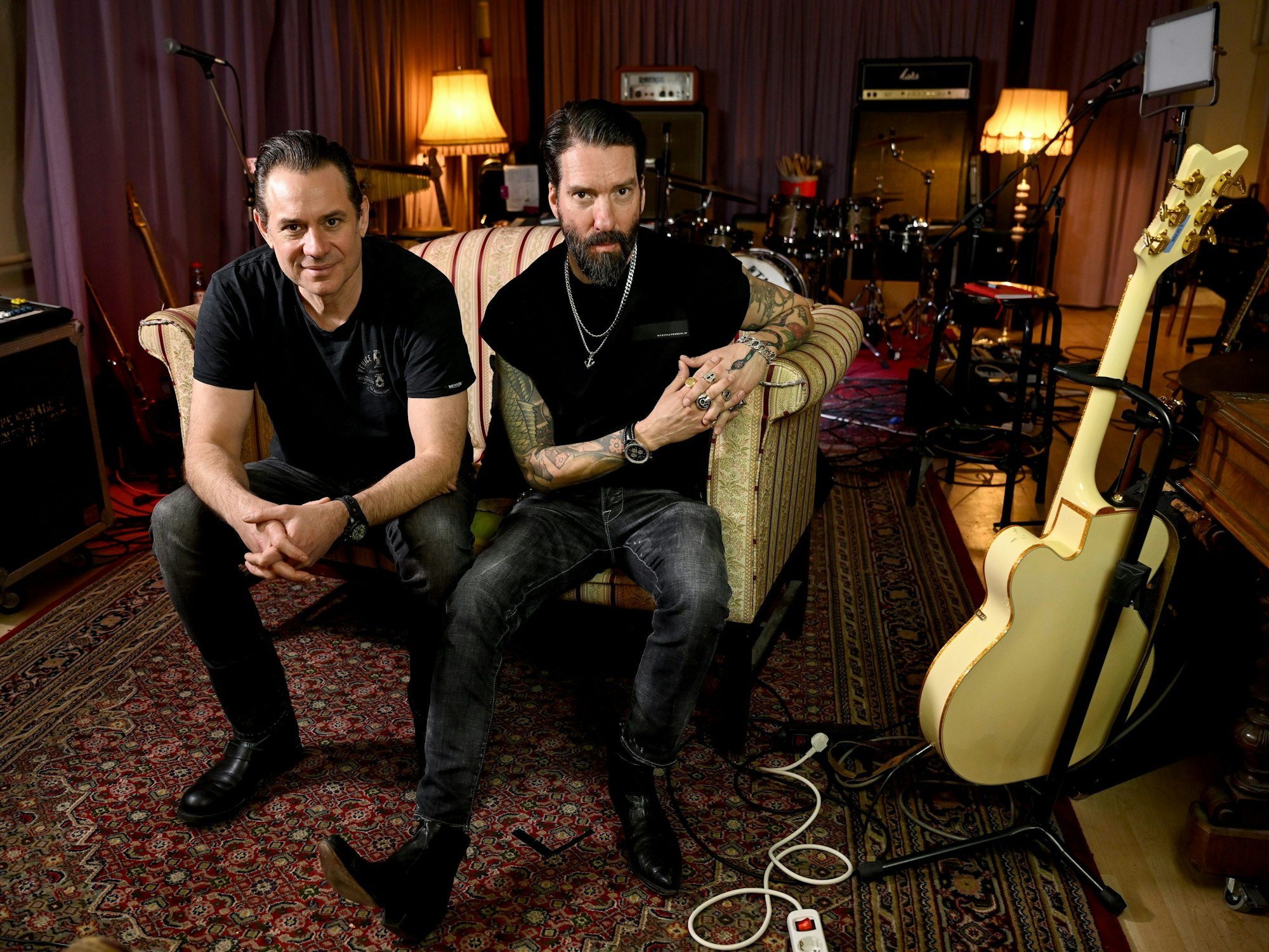 Die Musiker Alec Völkel und Sascha Vollmer sitzen auf einem Sofa.