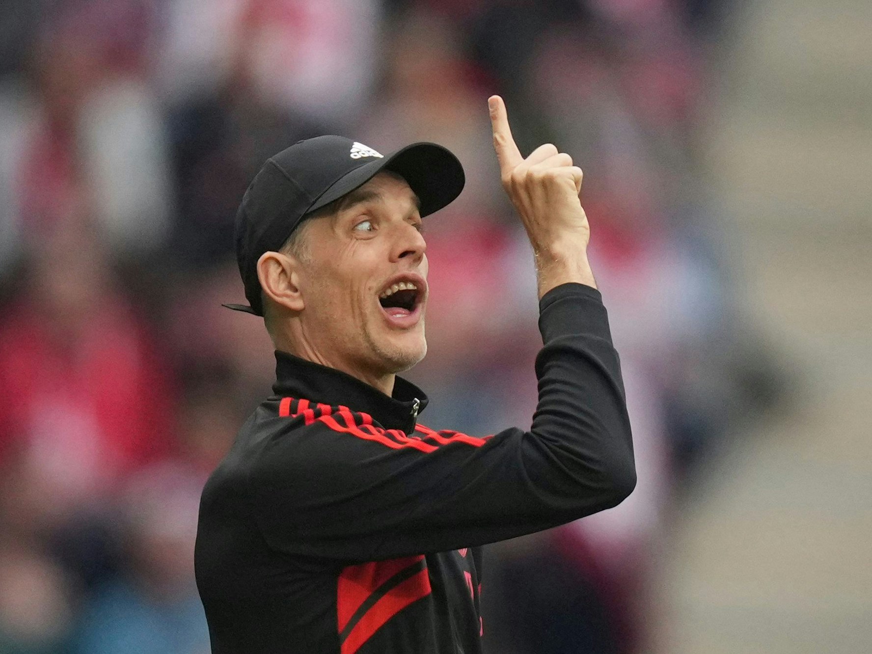 Thomas Tuchel zeigt nach oben und zieht eine Grimasse.