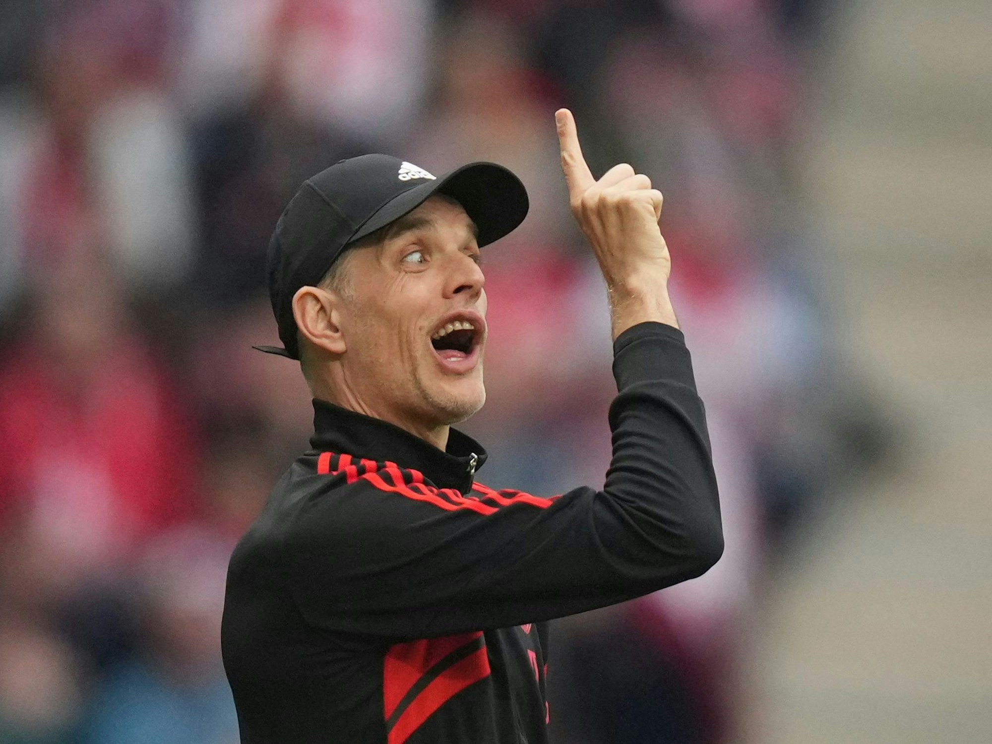 Thomas Tuchel zeigt nach oben und zieht eine Grimasse.