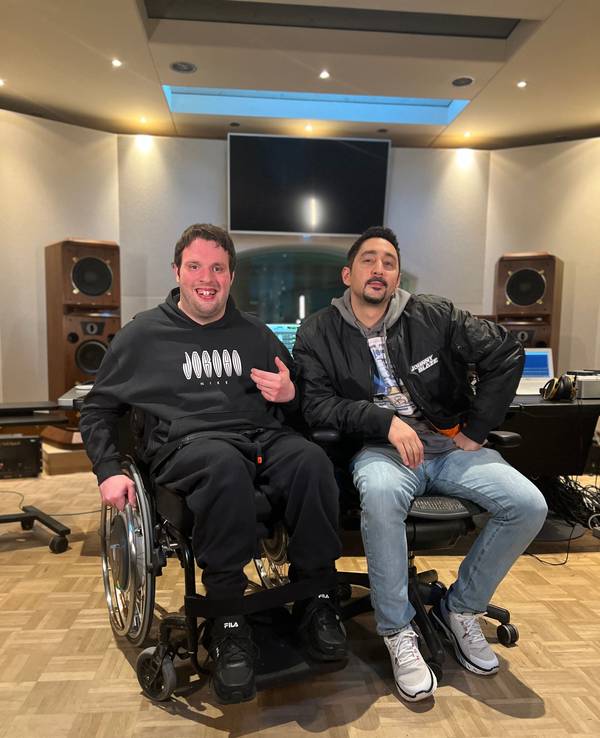 Rapper Rolling G sitzt neben Rapper Eko Fresh. Beide schrieben zusammen einen Song namens „Neue Wege“ und möchten auf die fehlende Barrierefreiheit in Deutschland aufmerksam machen.