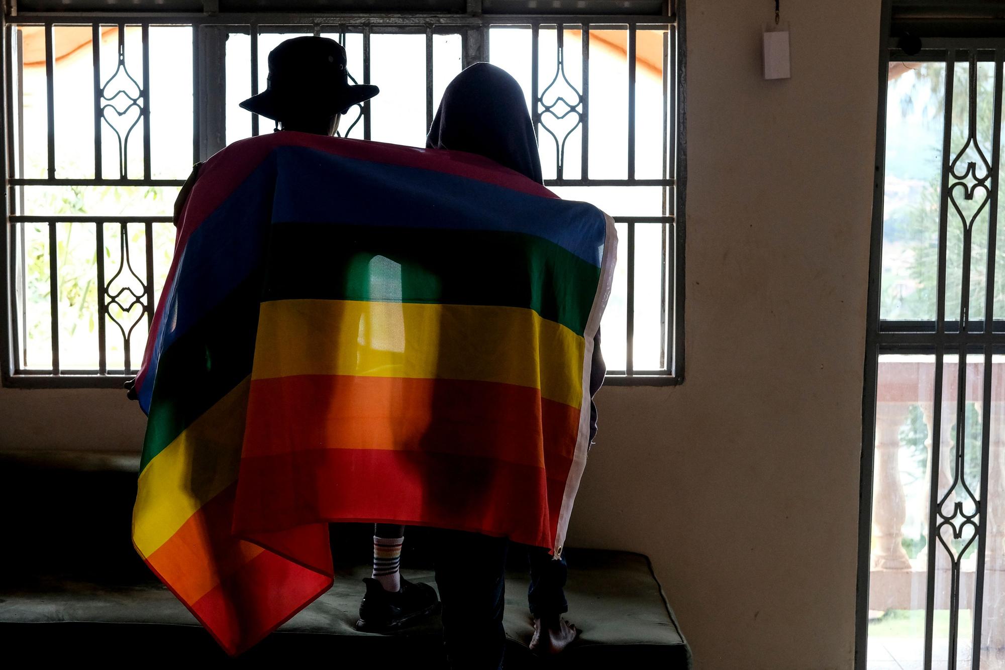 Ein Paar bedeckt sich mit einer Pride-Fahne. In Uganda hat das Parlament ein überarbeitetes Gesetz gegen Homosexuelle verabschiedet.