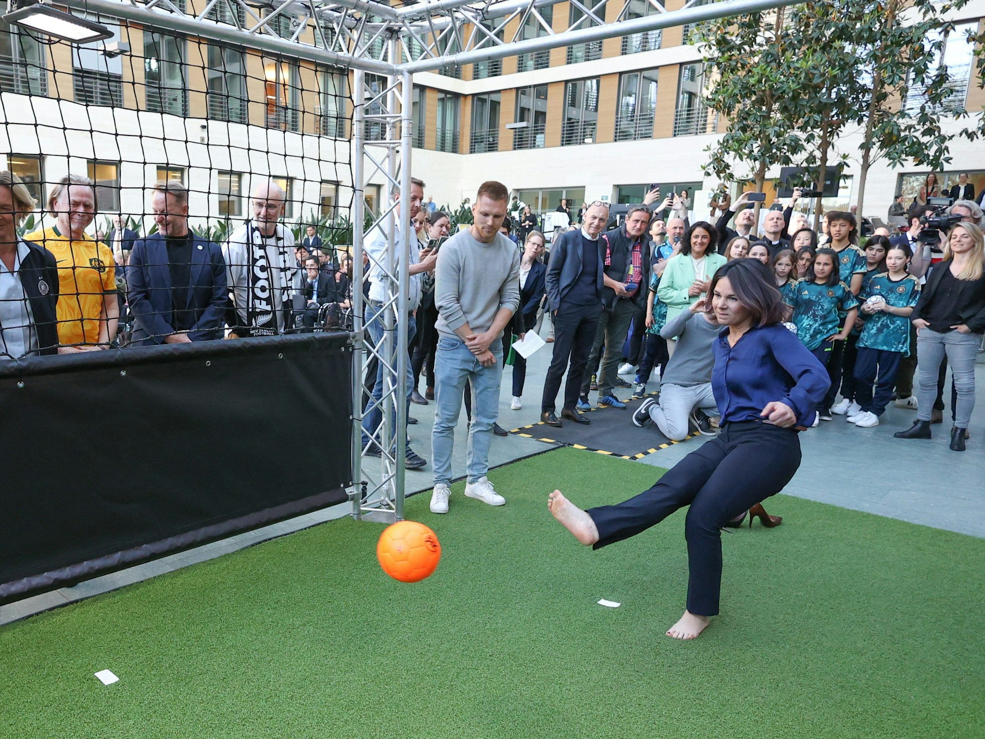 Annalena Baerbock versucht mit ihrem Schuss beim WM-Kick-Off im Auswärtigen Amt einen Roboter-Torwart zu überwinden.