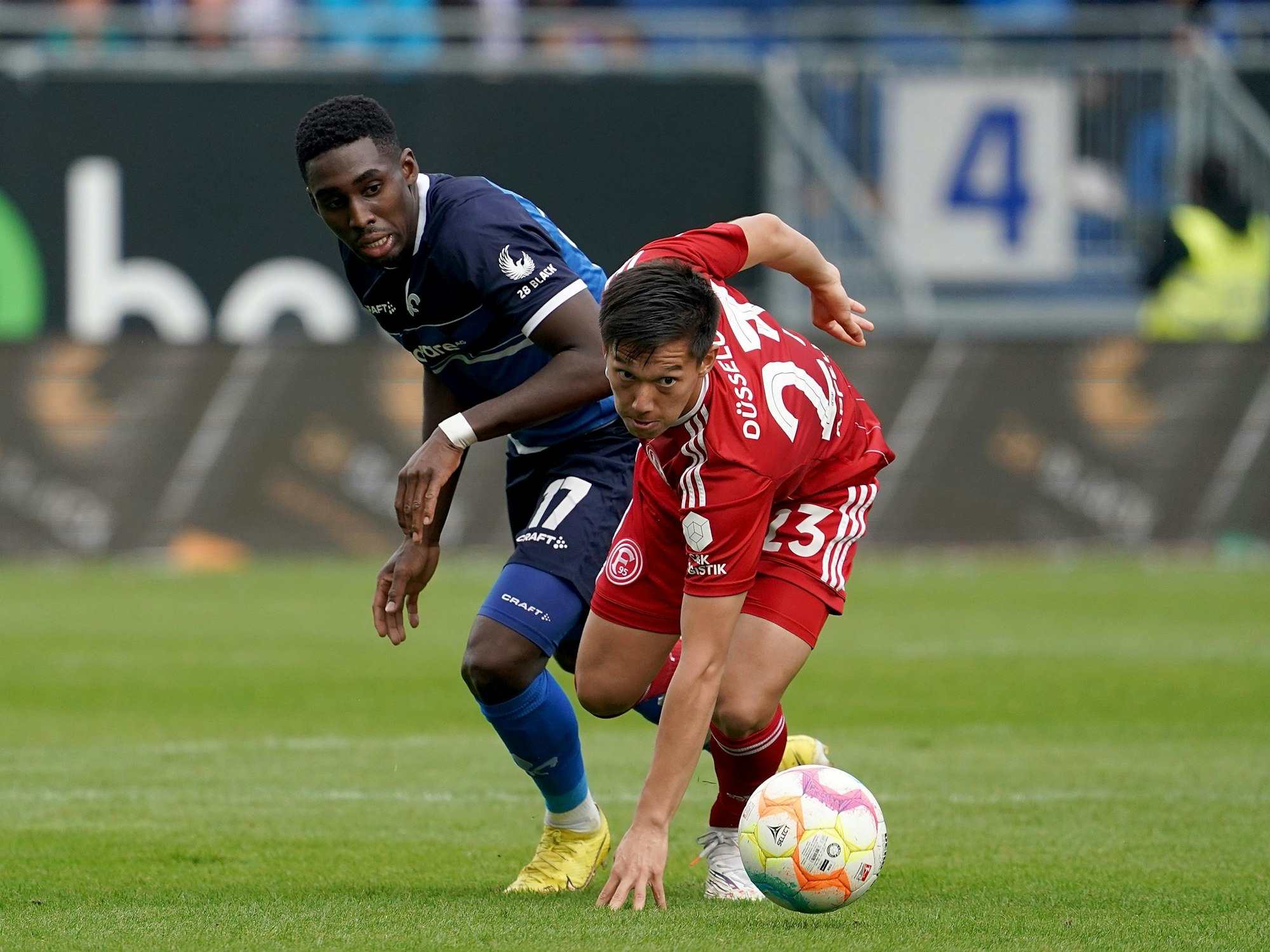 Darmstadts Frank Ronstadt und Düsseldorfs Shinta Appelkamp kämpfen um den Ball.