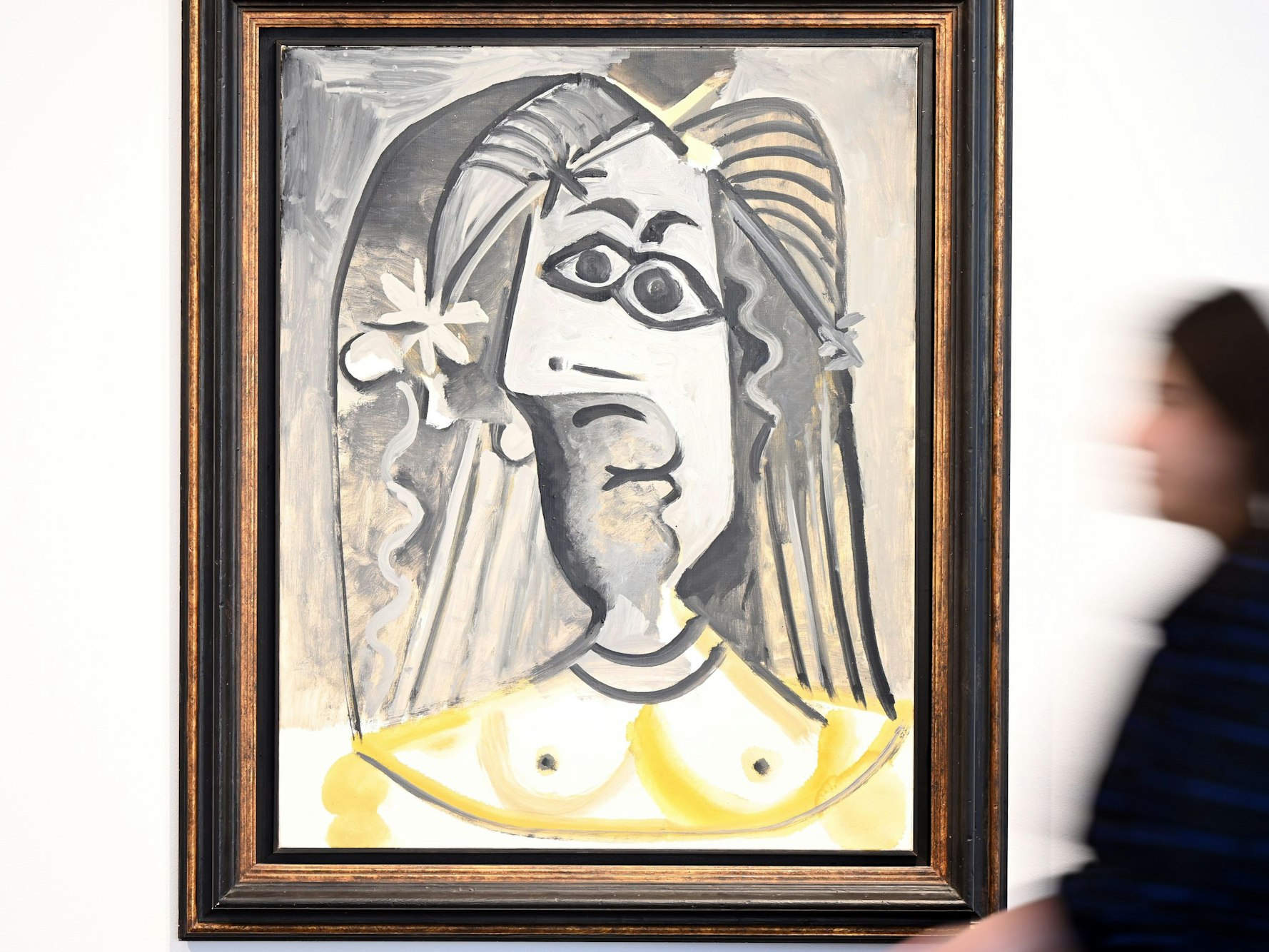 Eine Mitarbeiterin des Auktionshaus Van Ham geht am Bild "Buste de femme" aus dem Jahr 1971 von Pablo Picasso vorbei.