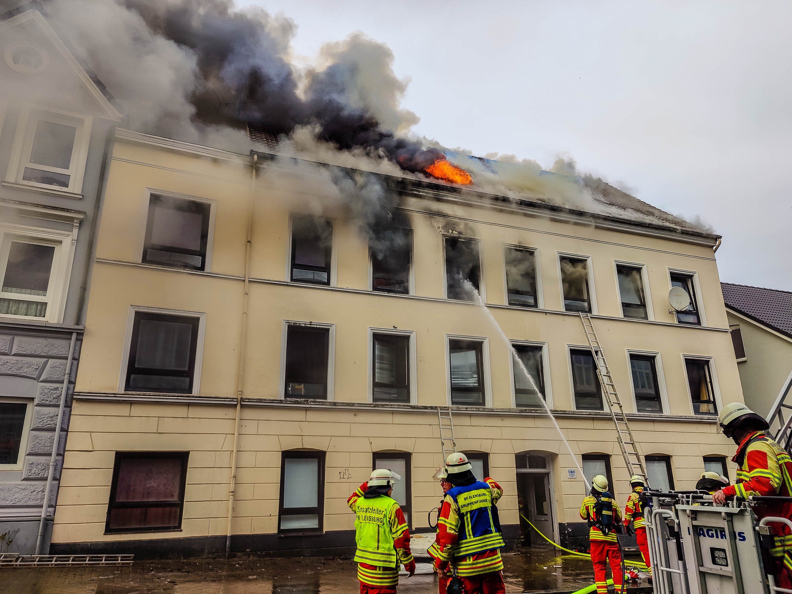 Die Feuerwehr ist bei einem Brand in Flensburg im Einsatz. In Flensburg ist am Donnerstag ein großes Feuer ausgebrochen. Zwei Menschen sind bei dem Brand ums Leben gekommen. Weitere Menschen seien durch das Feuer verletzt worden.