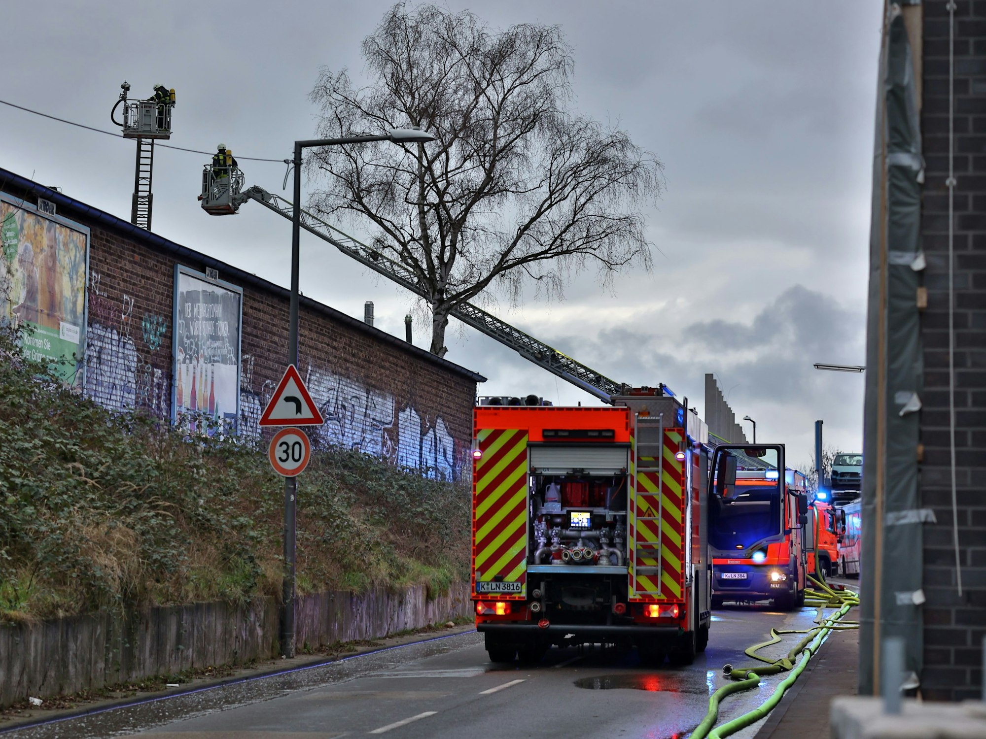 Mehrere Wagen der Feuerwehr im Einsatz in einer engen Straße.