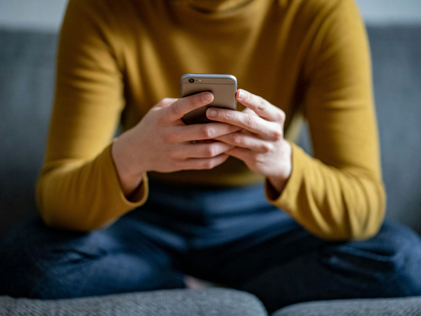 Eine junge Frau hält ein Smartphone in der Hand, hier im April 2021 in Berlin.