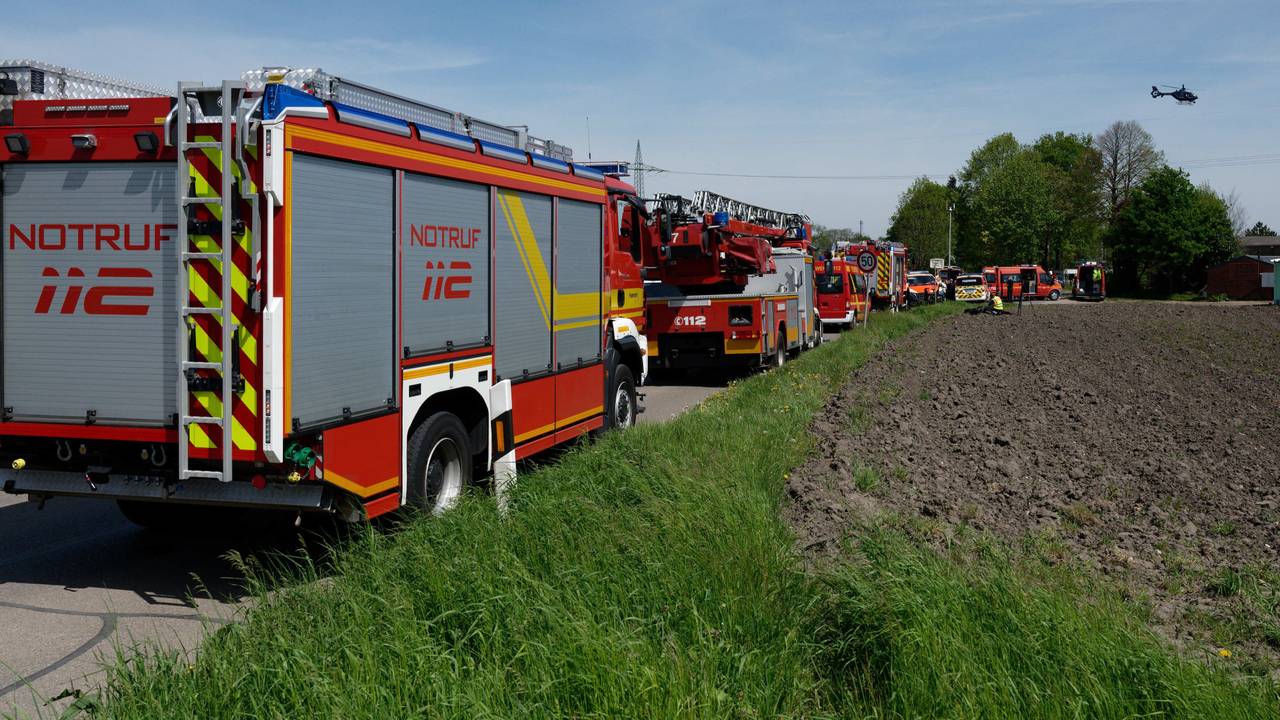 Fahrzeuge der Einsatzkräfte stehen am 4. Mai 2023 auf einer zum Unfallort führenden Straße. Bei dem Unfall in Hürth bei Köln sind am Donnerstag nach Angaben der Bundespolizei zwei Menschen ums Leben gekommen.