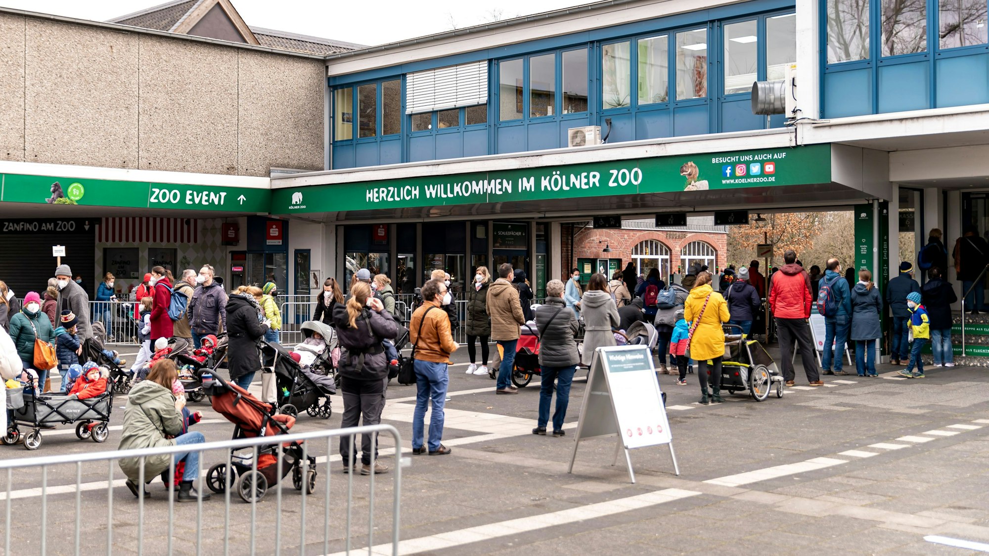 Menschen stehen in der Schlange vor dem Kölner Zoo.