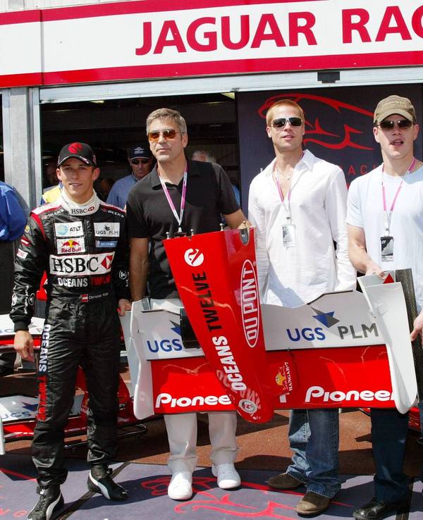 Die Schauspieler George Clooney (2.v.l.), Brad Pitt (Mitte) und Matt Damon (2.v.r.) anlässlich der „Oceans 12“-Filmpromotion zu Gast bei den Jaguar-Cosworth-Piloten Christian Klien (l.) und Mark Webber (r.)