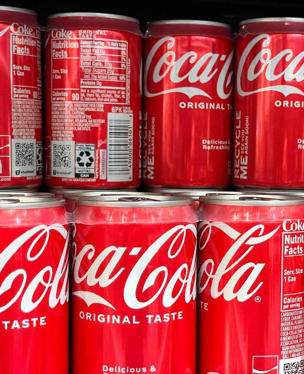 Zu sehen sind Coca-Cola Dosen aufgereiht.