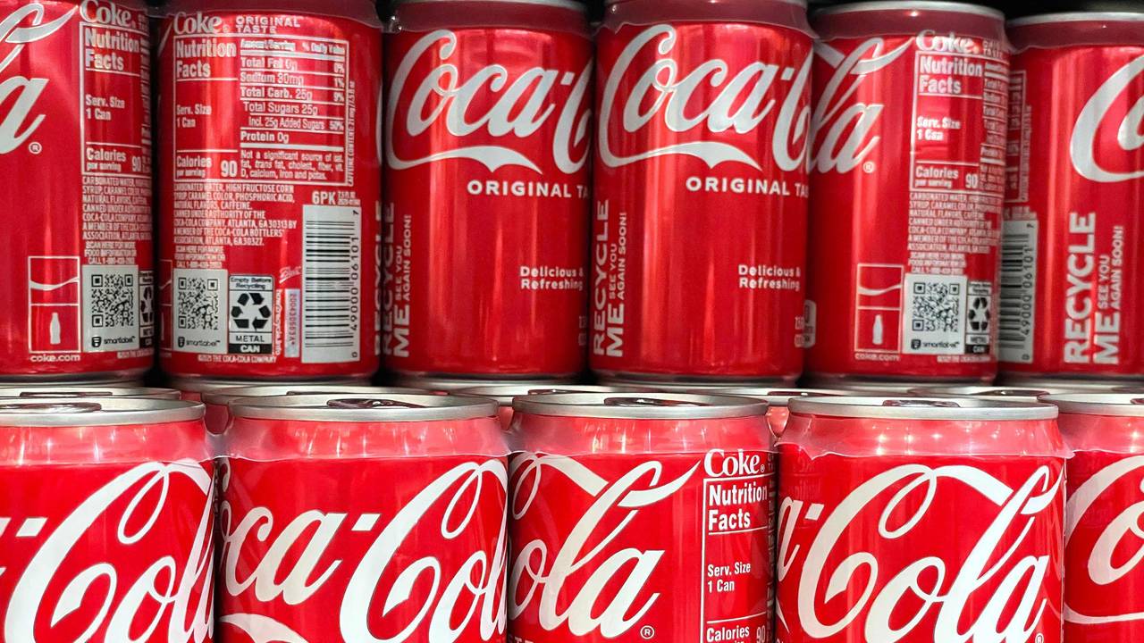 Zu sehen sind Coca-Cola Dosen aufgereiht.