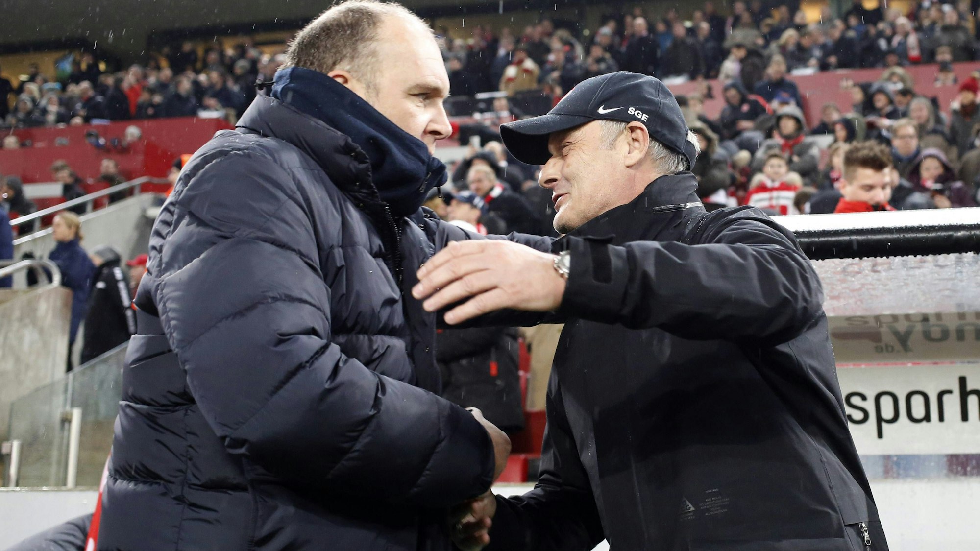 Jörg Schmadtke und Armin Veh umarmen sich vor einem Spiel in Köln.