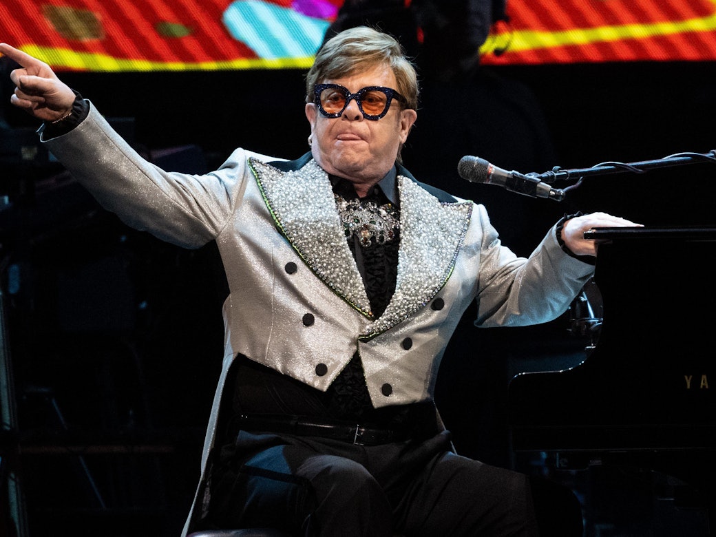 Der Sänger und Pianist Elton John sitzt in der Olympiahalle bei einem Konzert im Rahmen seiner „Farewell Yellow Brick Road Tour 2023“ auf der Bühne.