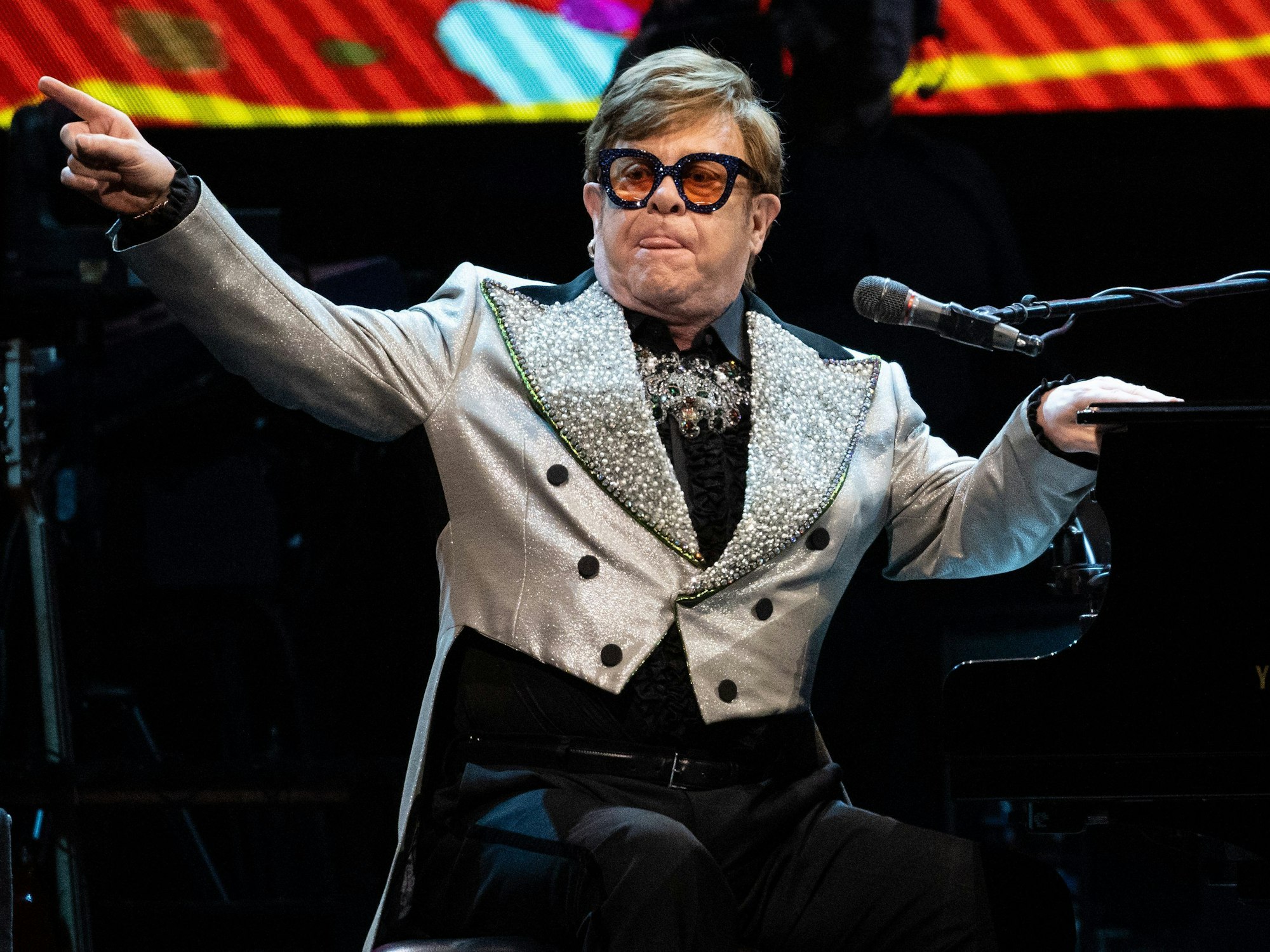 Der Sänger und Pianist Elton John sitzt in der Olympiahalle bei einem Konzert im Rahmen seiner „Farewell Yellow Brick Road Tour 2023“ auf der Bühne.