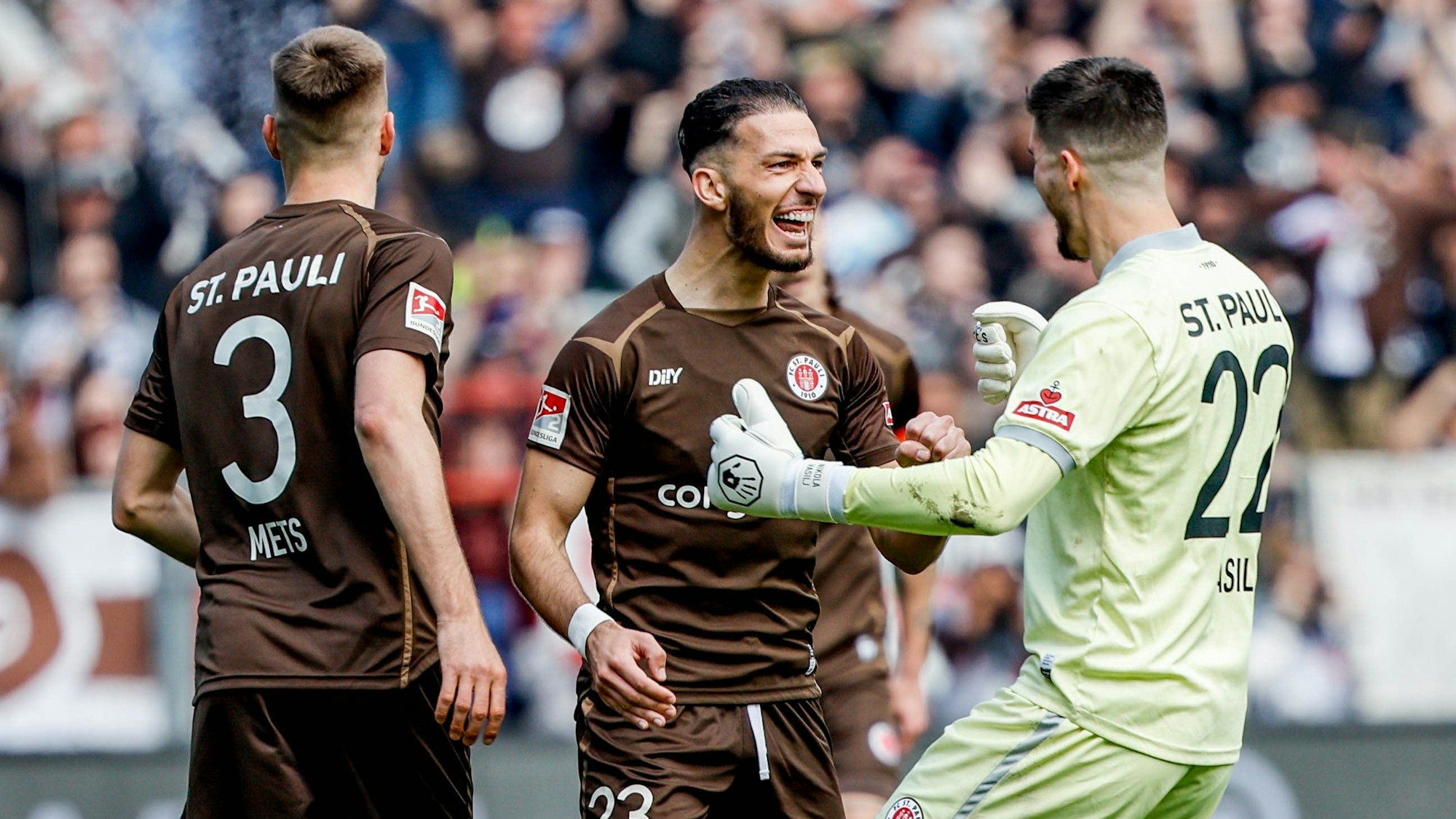 St. Paulis Karol Mets (l-r), Leart Paqarada und Torwart Nikola Vasilj feiern den Treffer zum 1:0.