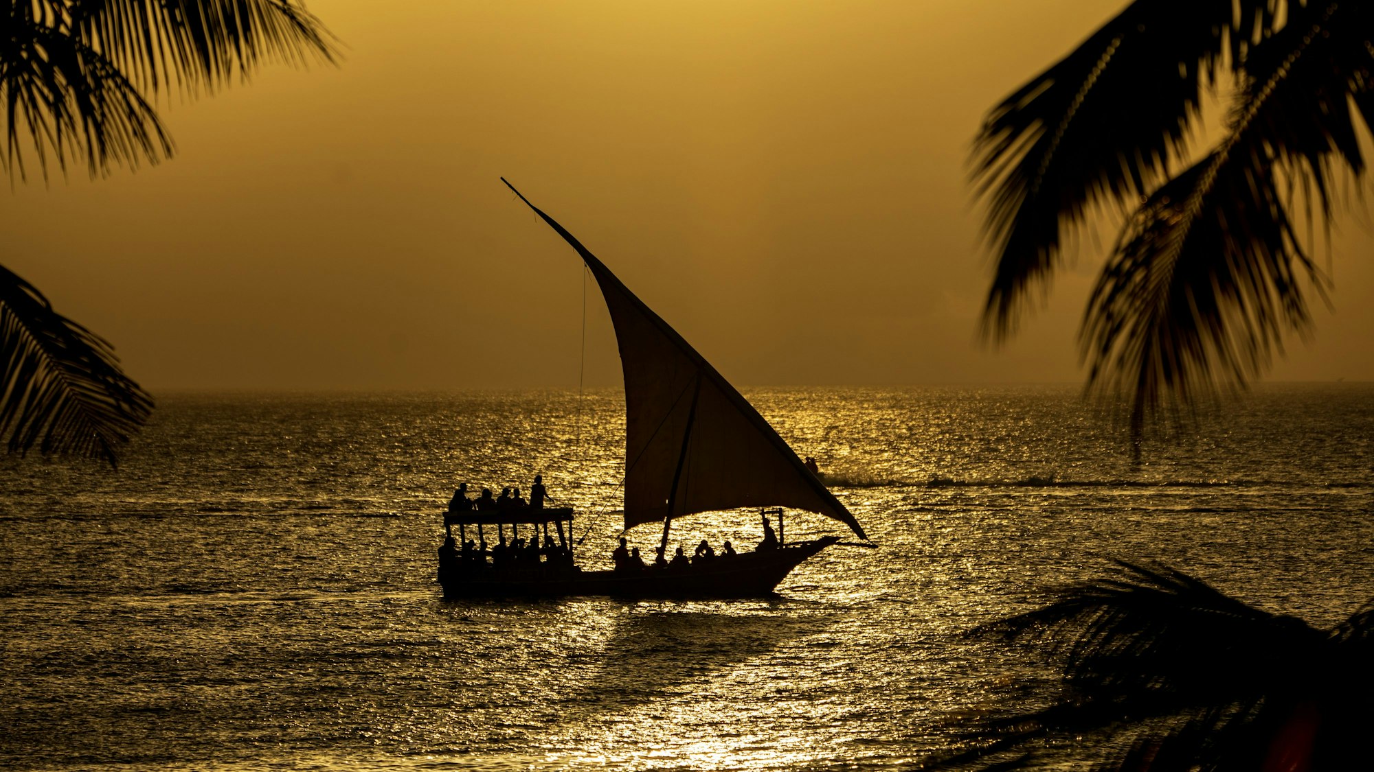 Menschen segeln mit einem Segelboot auf dem Meer vor der Küste Ostafrikas.