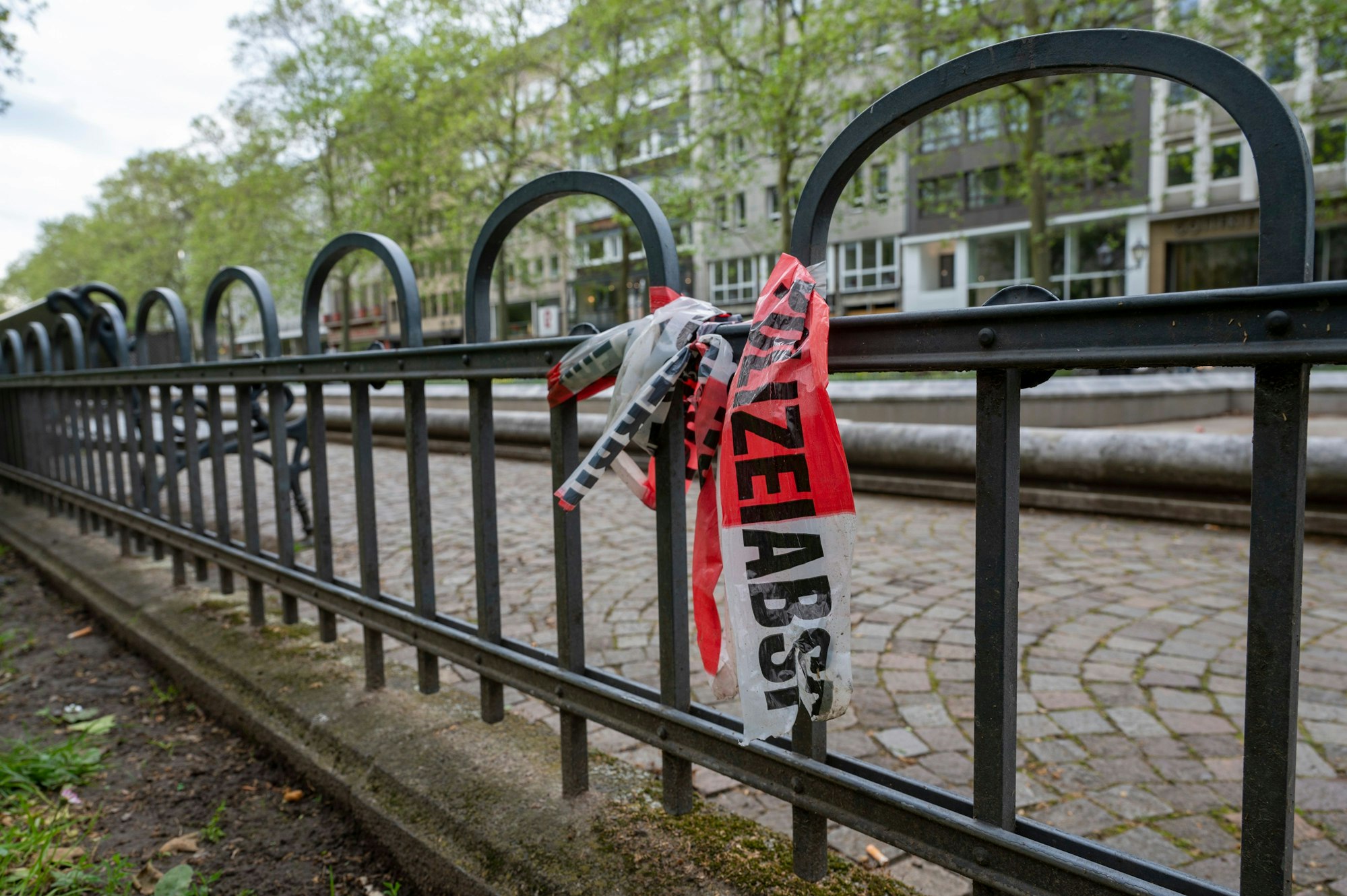 Ein Stück der Polizeiabsperrung hängt am Zaun.