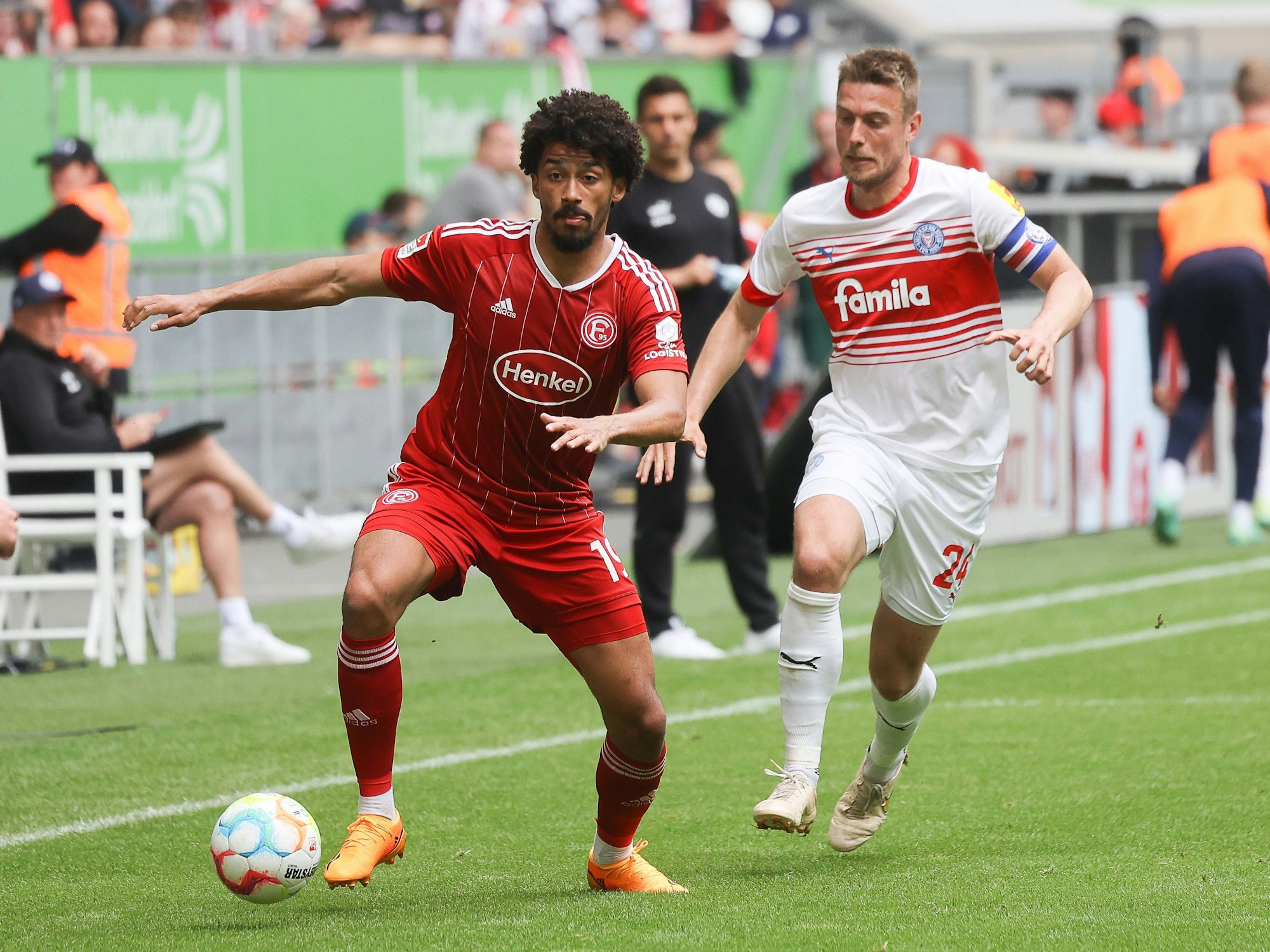 Emmanuel Iyoha führt den Ball, Kiels Hauke Wahl verfolgt ihn.